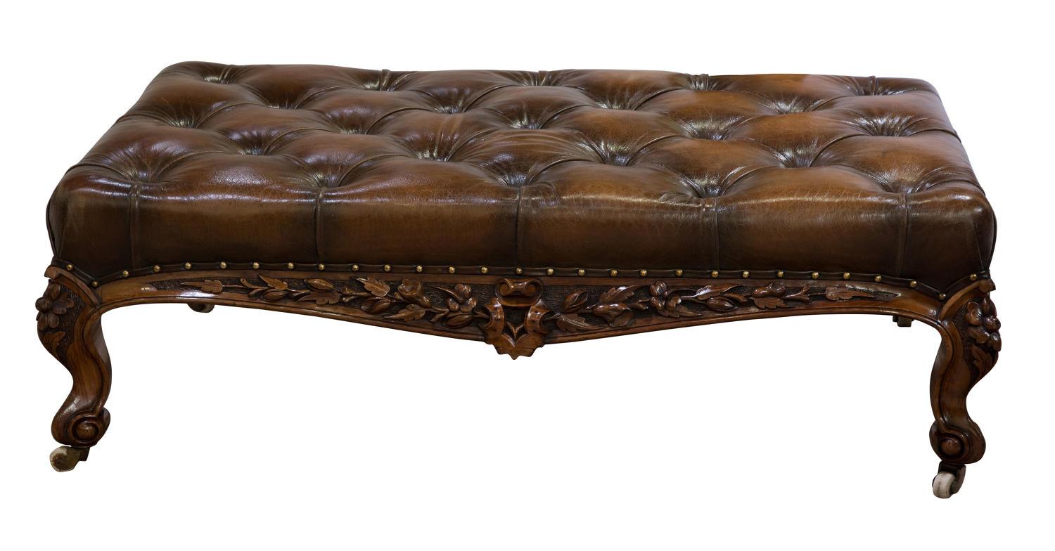 Fine quality Victorian carved walnut stool of large size with beautifully crisp carved detail to four sides deep buttoned tan hide, original castors, circa 1850.