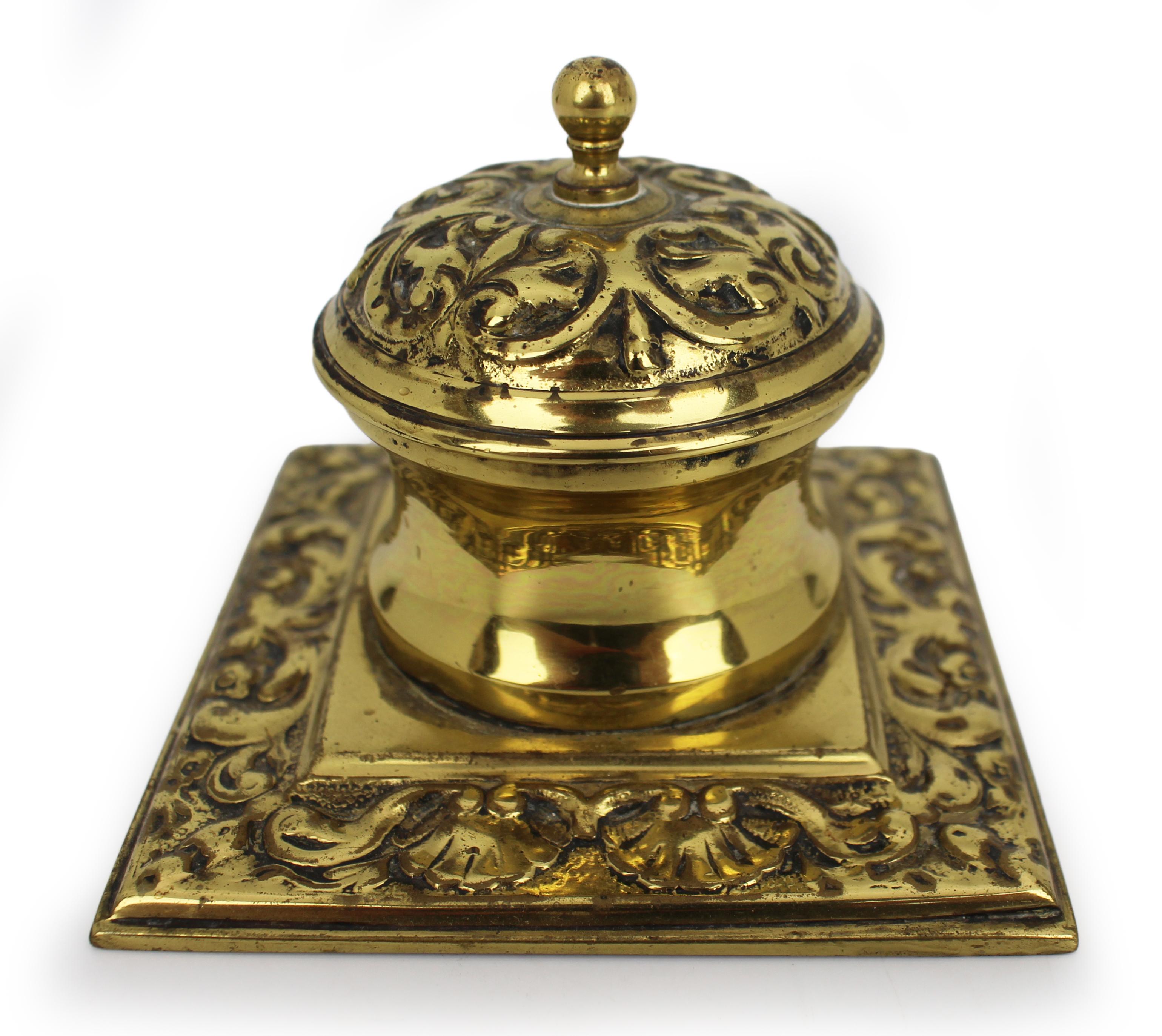 Victorian Cast Brass Inkwell with Ornamental Scrollwork, England, circa 1880
A finely cast late Victorian brass inkwell of compact square form, English, circa 1880.
The lid and base are richly adorned with scrolling foliate and shell motifs in low