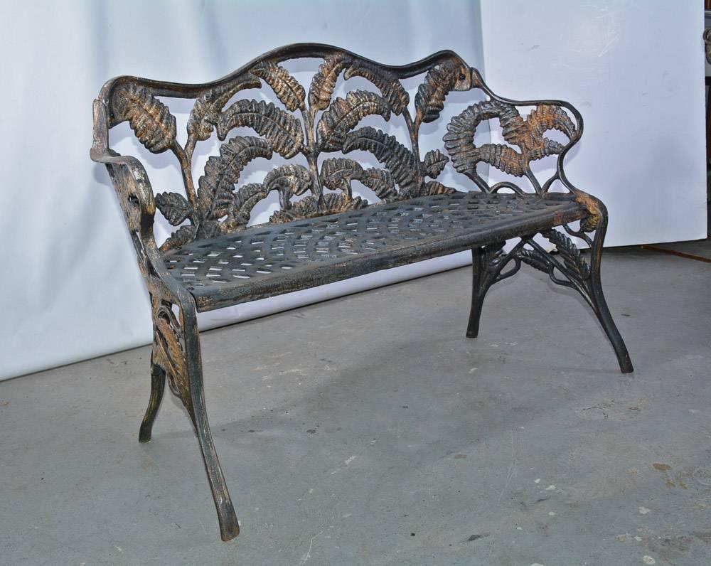 The Victorian cast-iron garden bench is decorated with sprays of ferns on the back, arms and legs. The seat has an open filigree pattern. Sections of the settee were cast separately and then screwed together. The weight is substantial.

Seat