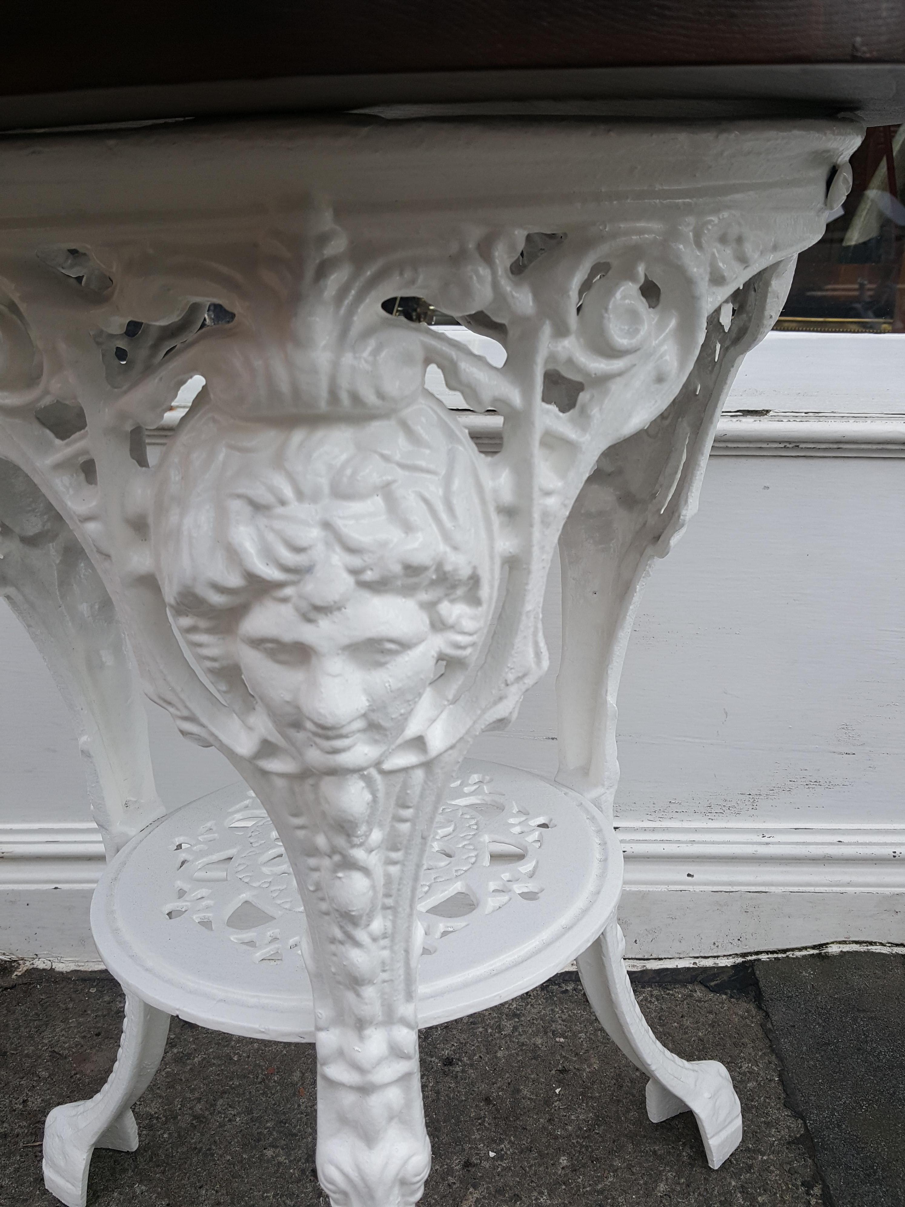 Victorian cast iron pub garden table with mahogany top decorated with cast portrait, hearts and lion paw feat, probably cast by Saxendale & Co Manchester, measure: 24
