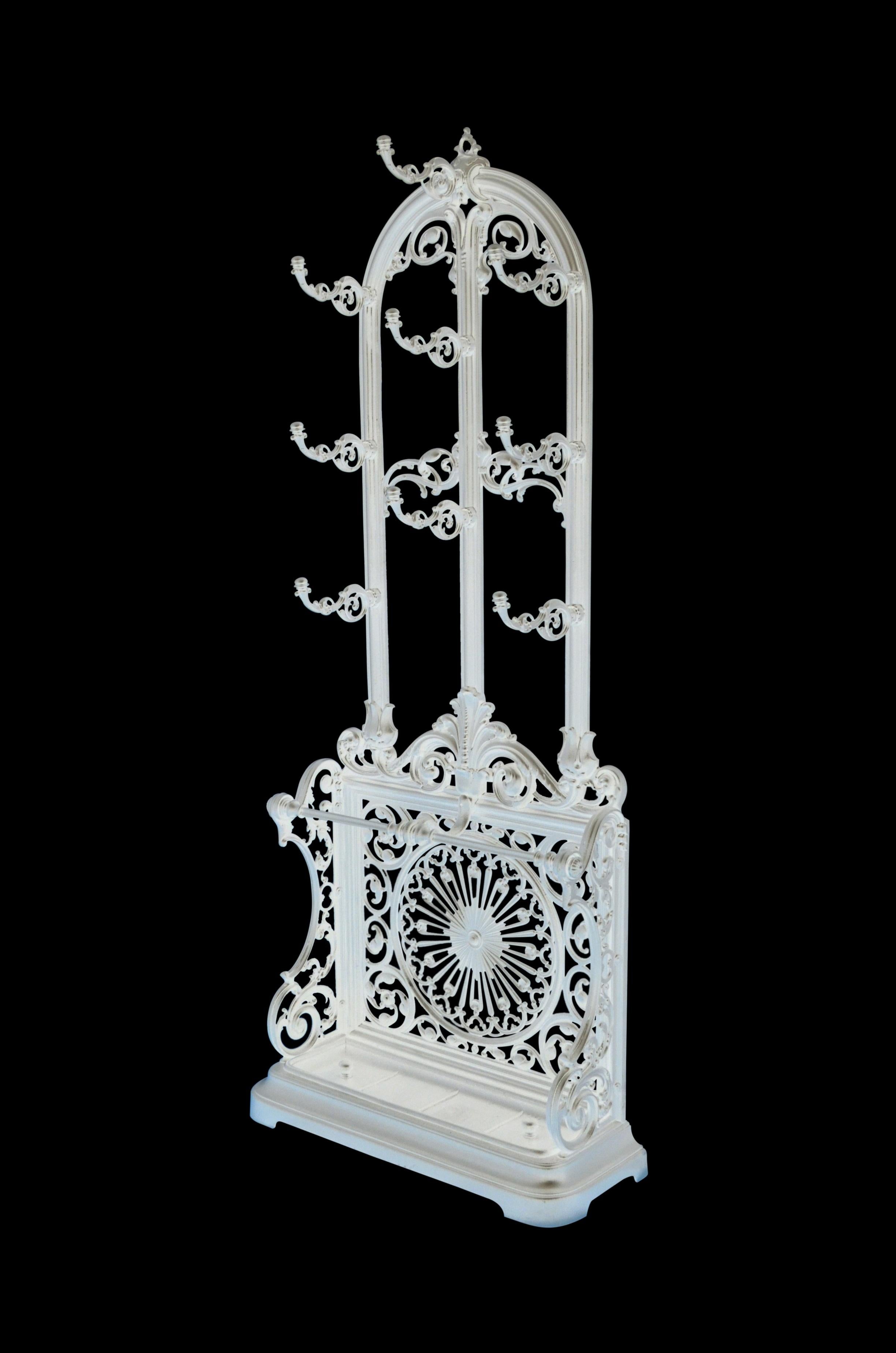 K0427, stylish and elegant Victorian cast iron coat stand, having arched top and 9 hat / coat hooks, terminating in scrolled decoration with umbrella holders on 2 supports and exceptional pierced design to back, an removable drip tray to base. This