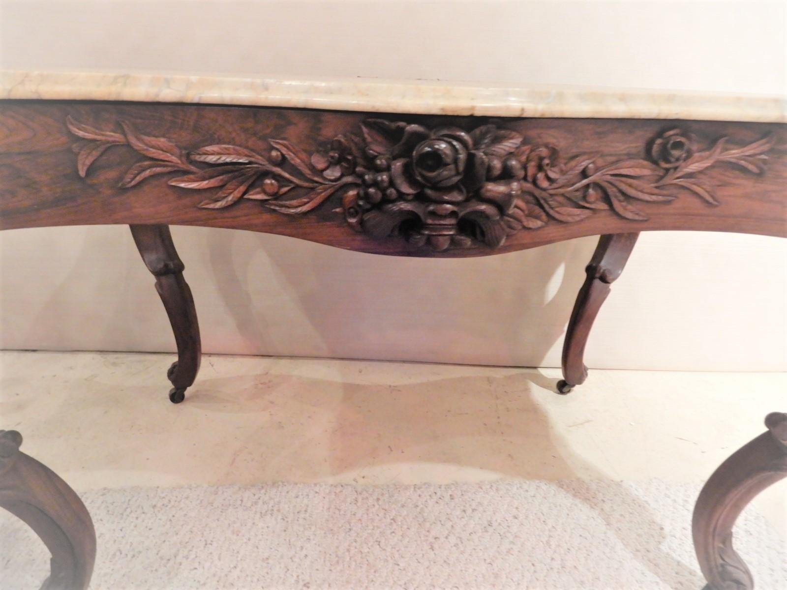 A center table : Victorian Rococo Revival rosewood marble-top. The table is strongly attributed to John Henry Belter who was known for his laminated furniture. This Rosewood table has block laminated construction which Belter used on his furniture.