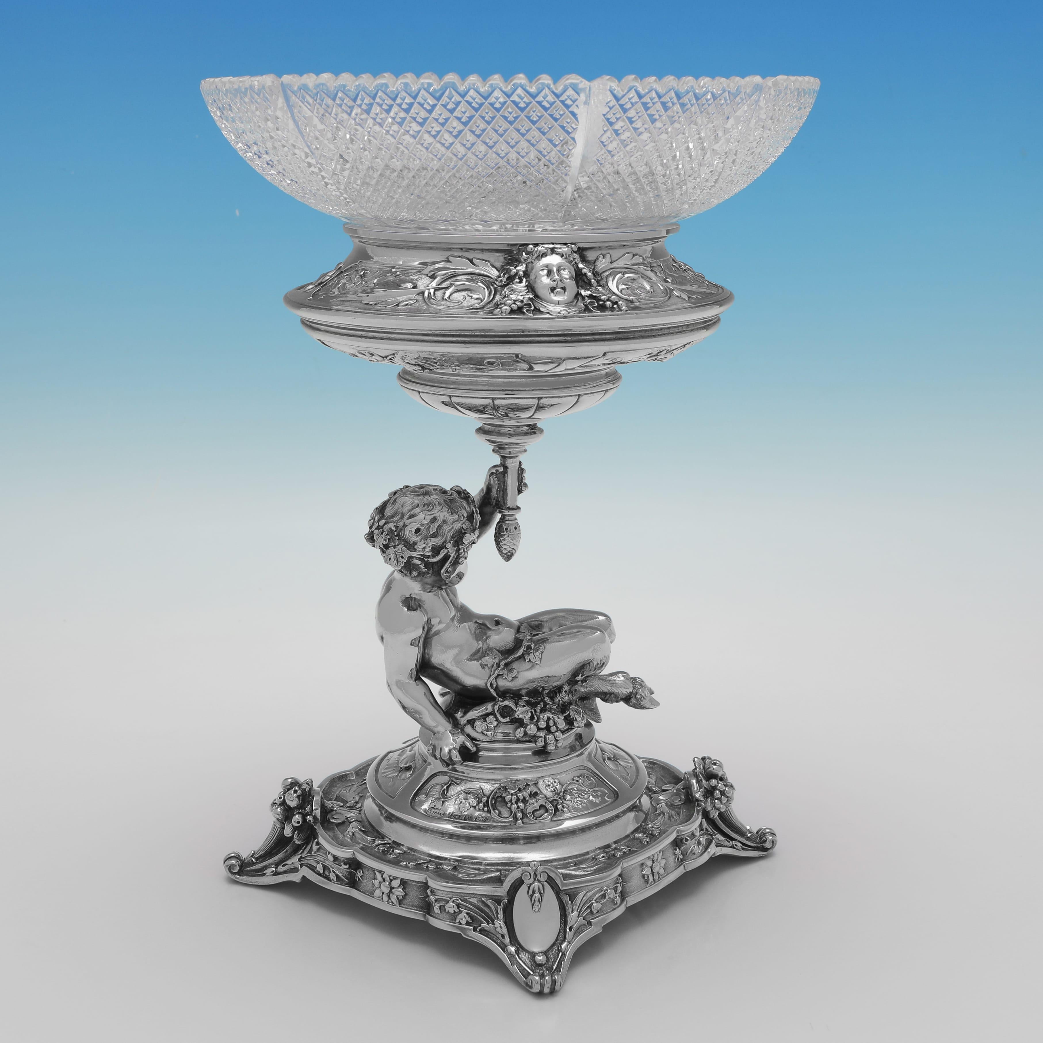Poinçonnée à Birmingham en 1890 et 1895 par Elkington & Co, cette étonnante suite victorienne de pièces maîtresses en argent sterling ancien comprend un plat central ovale en argent et en verre, ainsi qu'une paire de plats d'accompagnement ronds en