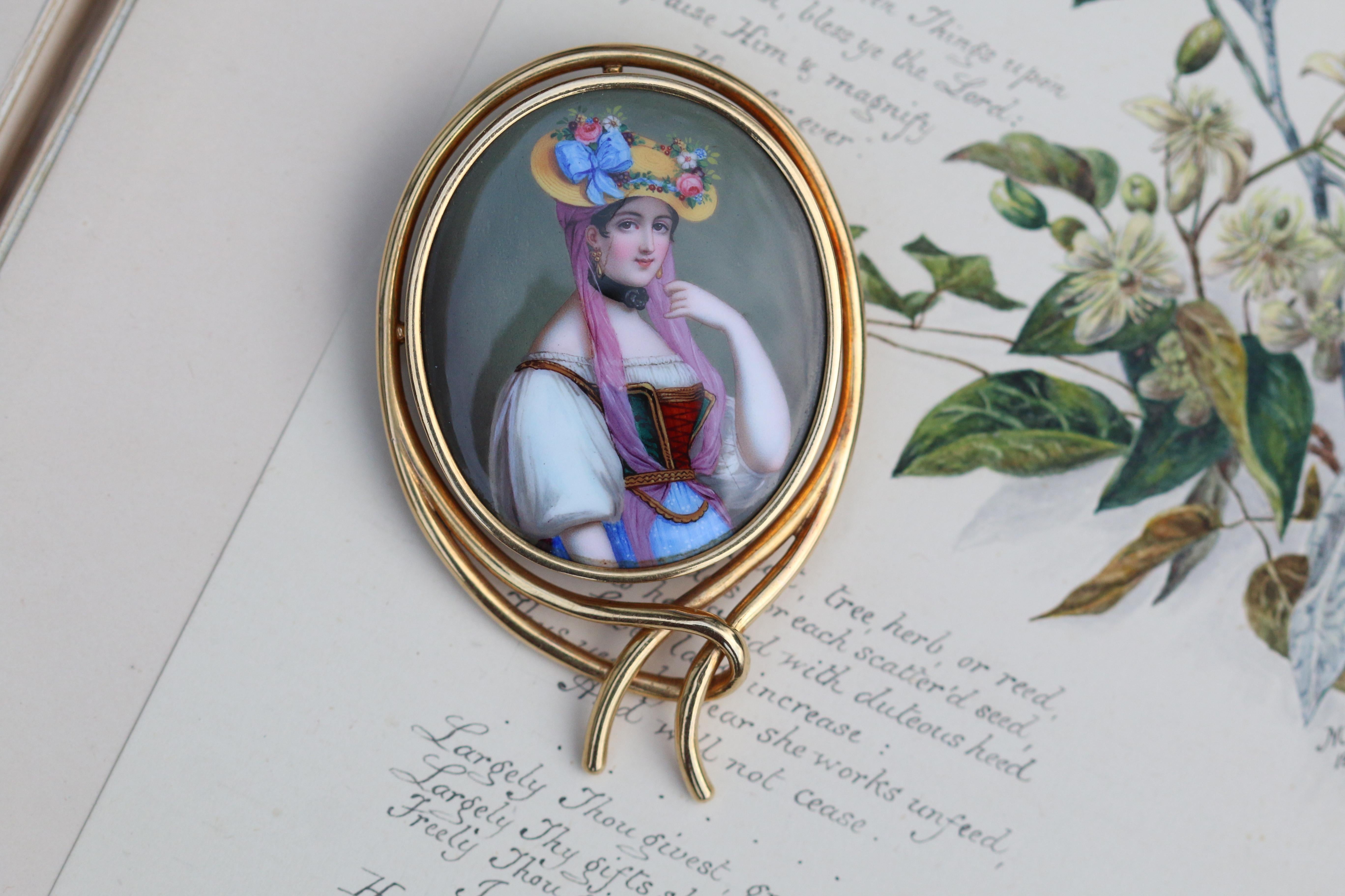 This absolutely breathtaking brooch has so much character, elegance and is simply a thing of beauty. A portrait of a woman wearing a woven hat painted on ceramic. Upon the hat is a wreath of flowers bursting with colours; pink, whites and blue