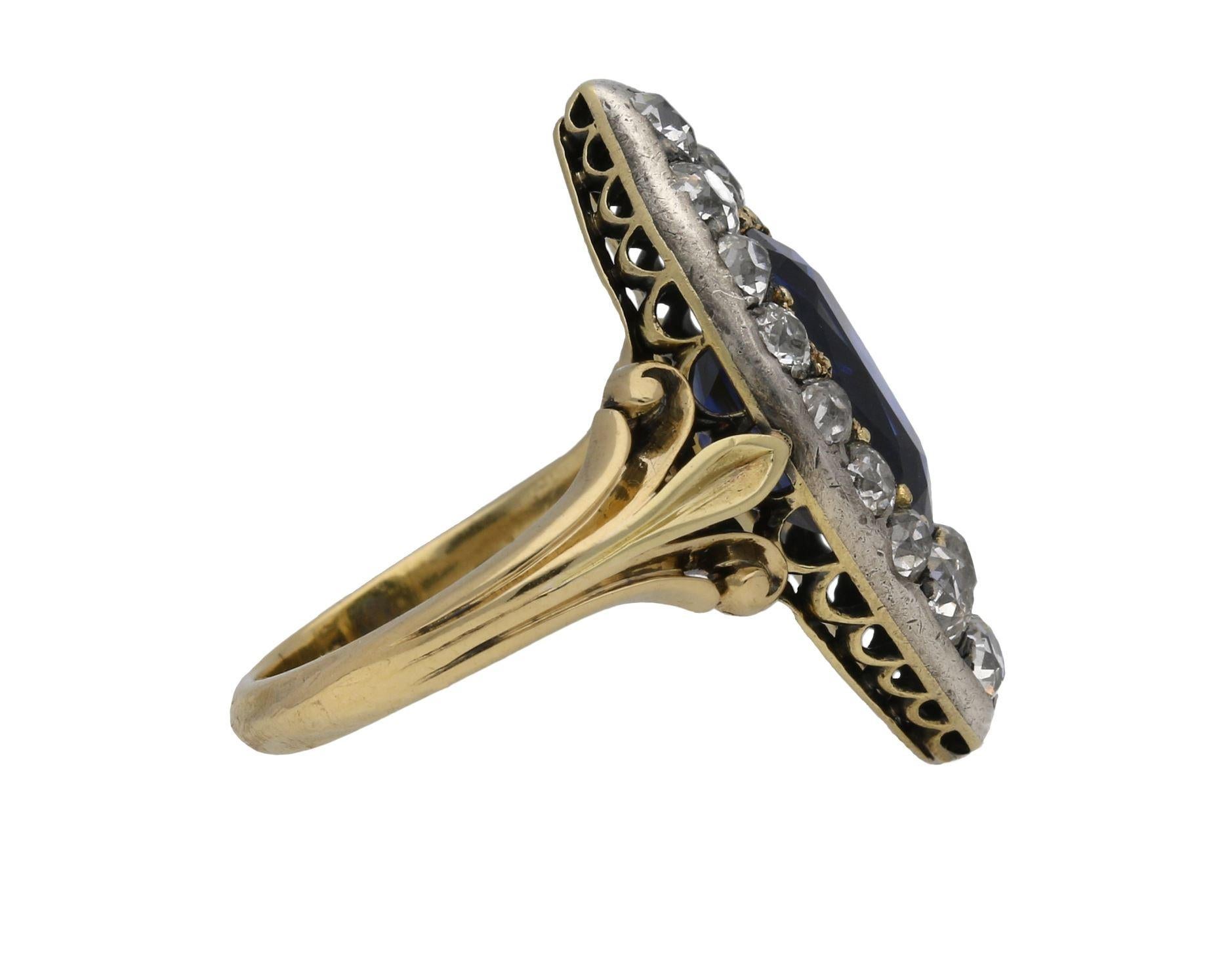 Anello vittoriano con zaffiro di Ceylon e diamanti a grappolo. Al centro è incastonato uno zaffiro di Ceylon naturale non valorizzato a forma di cuscino in un'incastonatura a grani aperti con un peso approssimativo di 4,50 carati, circondato da
