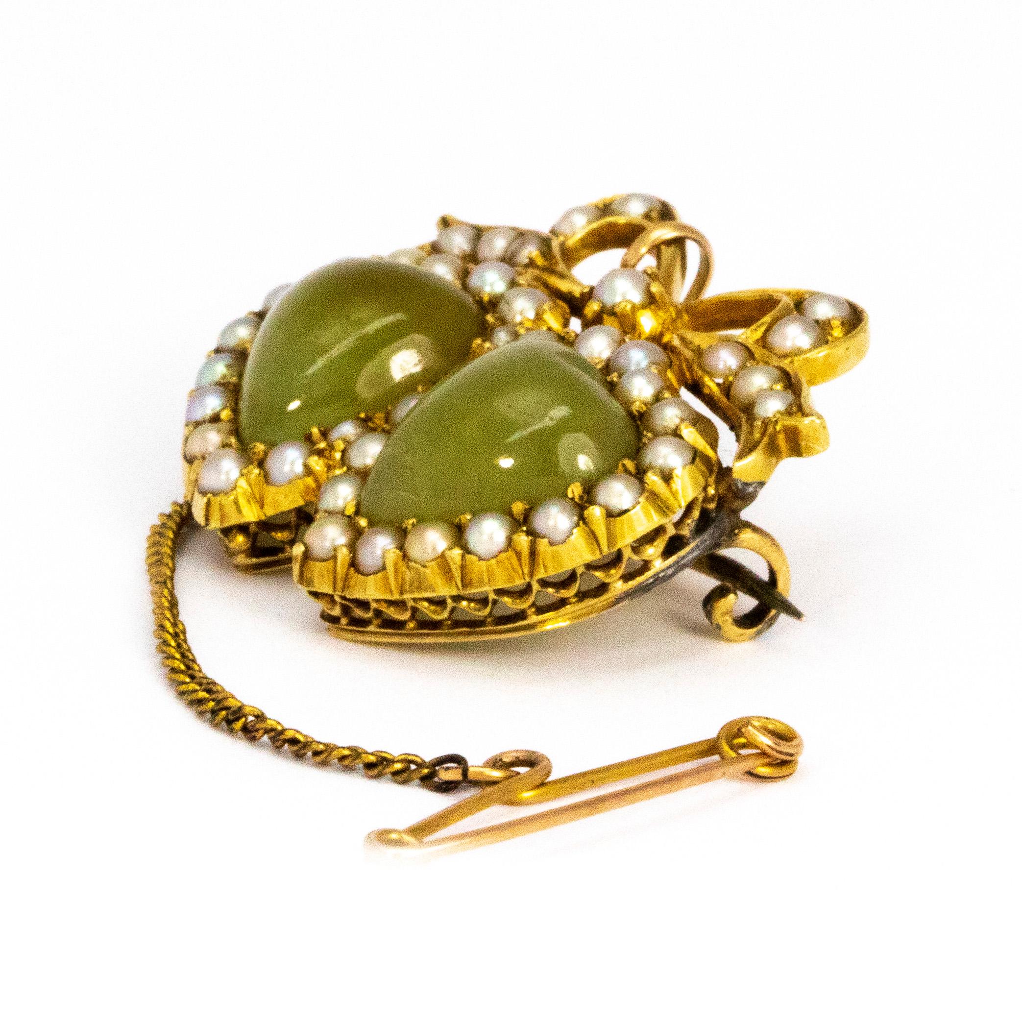 The two gorgeous glossy stones in this brooch are Chalcedony stones and are the most beautiful pale green colour. Surrounding the hearts are seed pearls and above the pearls carry on into bow detail. 

Dimensions: 26mm x 22mm 