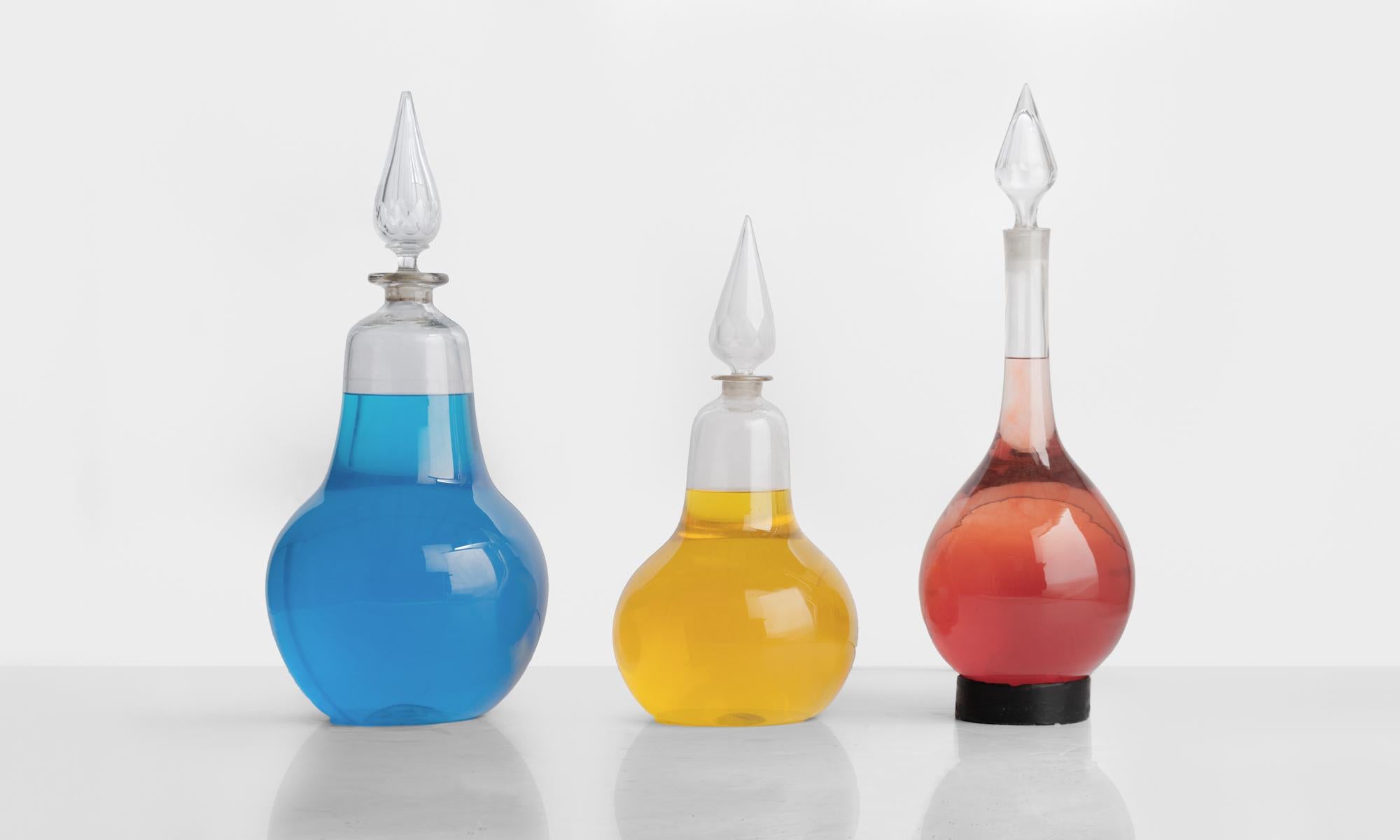 Victorian chemist carboys, circa 1870

Set of (three) handblown glass carboys with cut-glass stoppers.

Measurements of carboys from left to right: 12.5