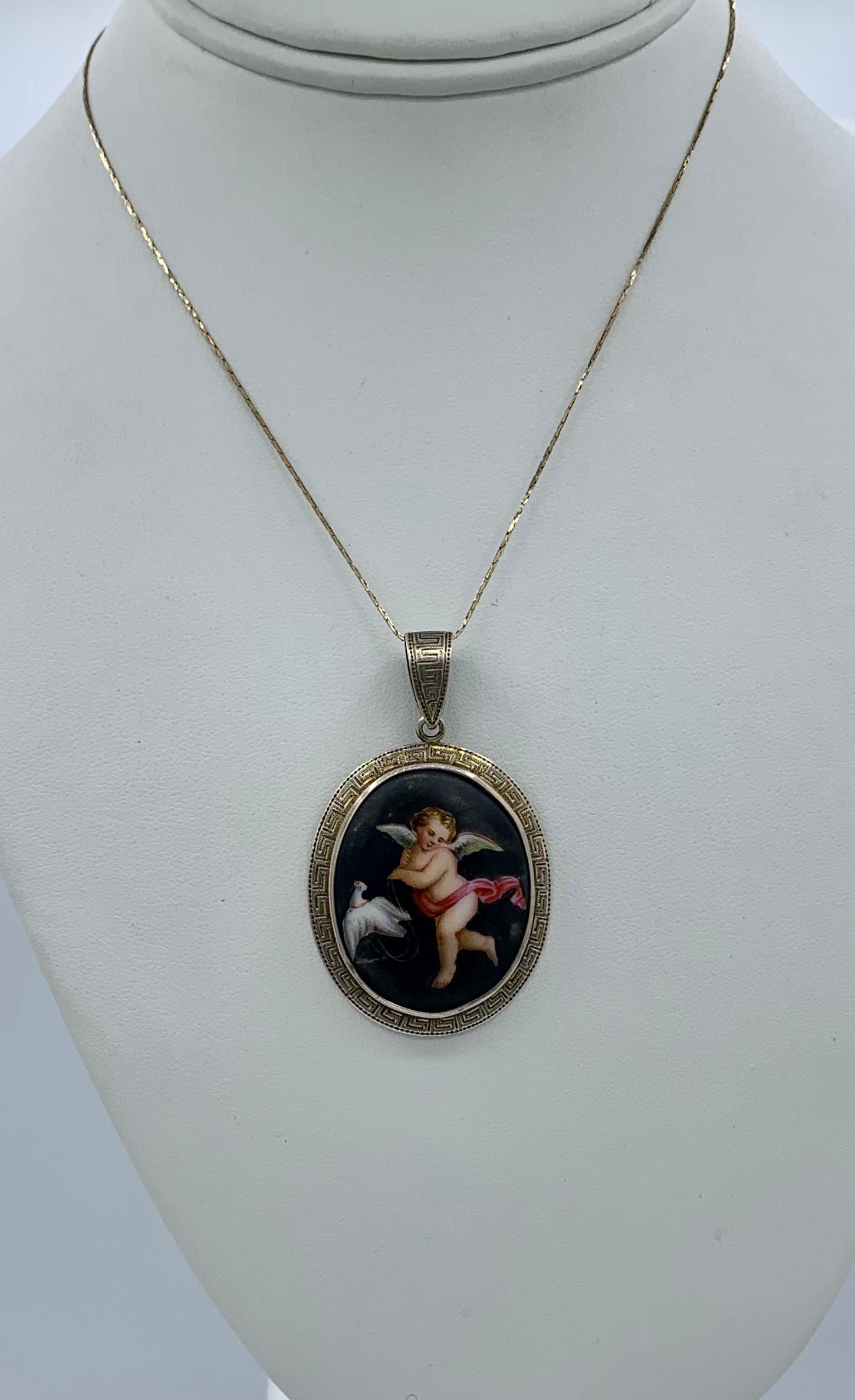 This is a very rare and wonderful Victorian pendant with a hand painted image of a Winged Cherub or Angel with a dove bird on a string set in a Greek Key motif setting in 9 Karat Rose Gold.  The romantic and charming image is beautifully hand