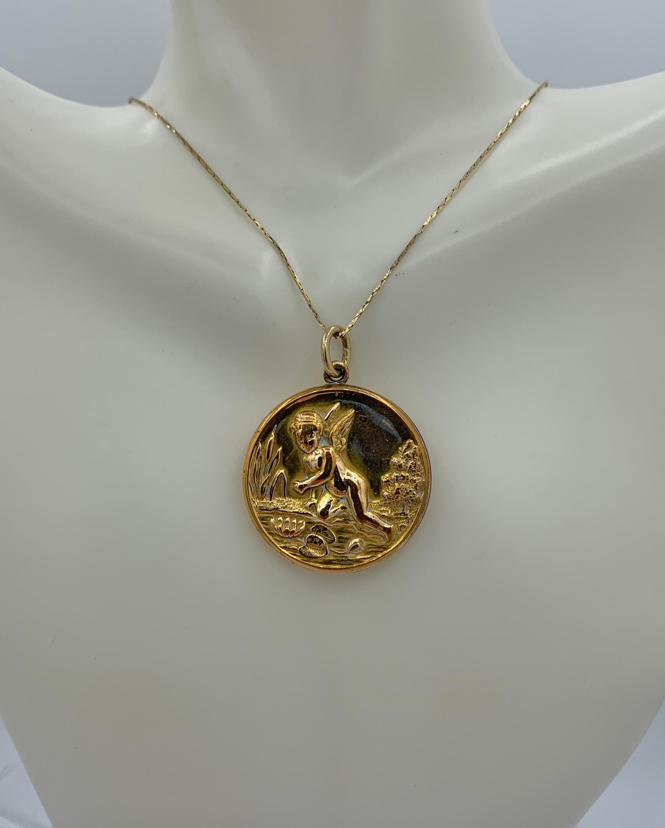 This is a wonderful and rare antique Victorian - Art Nouveau Cherub, Angel, Cupid Locket with Cupid in a Lily Pond with Lily Pads, Flowers, Cattails and Trees.  The design is absolutely exquisite and very rare.  The locket is gold filled.  The image