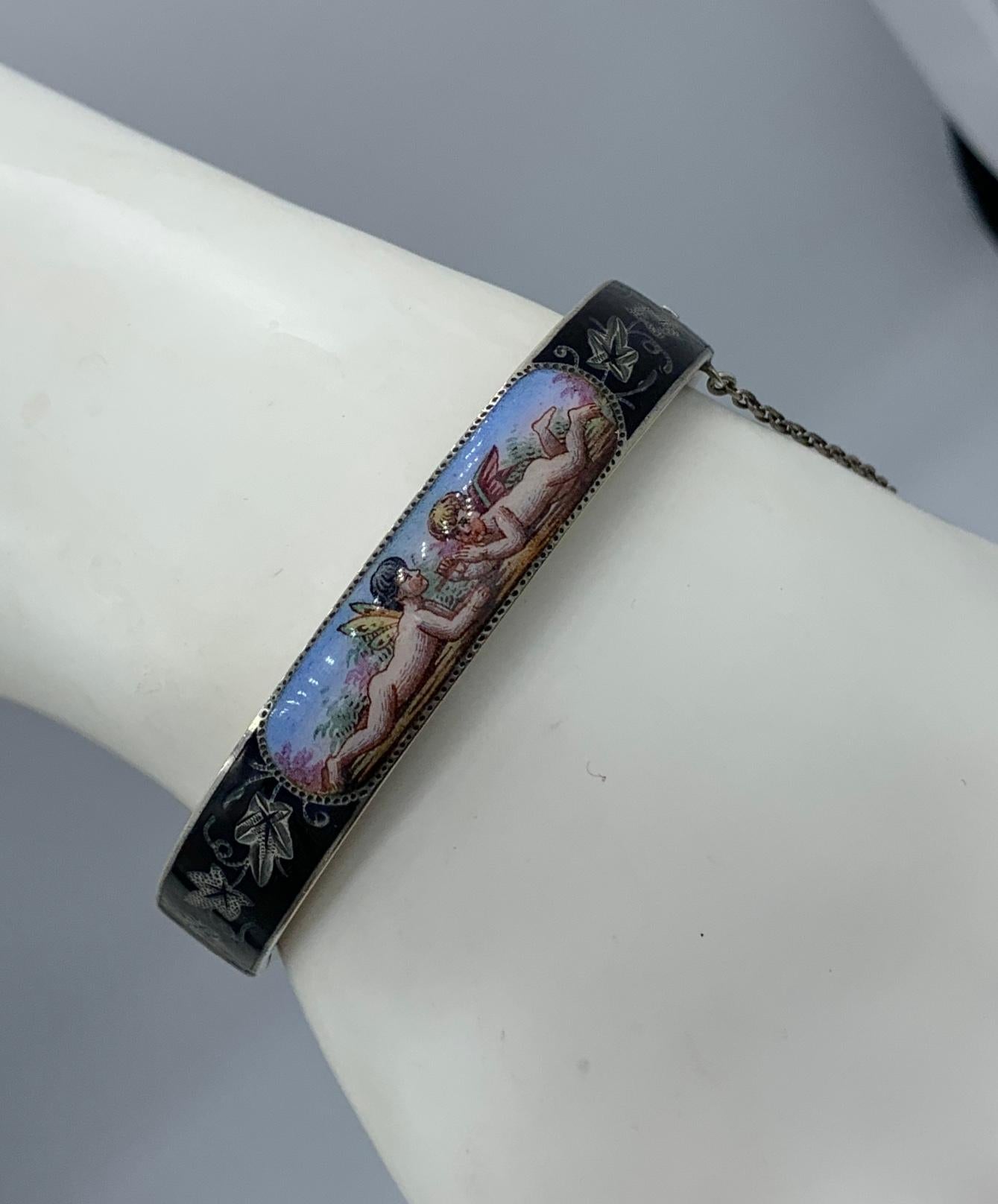 This is very rare and wonderful Victorian Enamel Bangle Bracelet with an image of two Winged Cherub or Angels lying on a grassy meadow with greenery behind with a beautiful blue sky.   The romantic and charming image is done in enamel with gorgeous