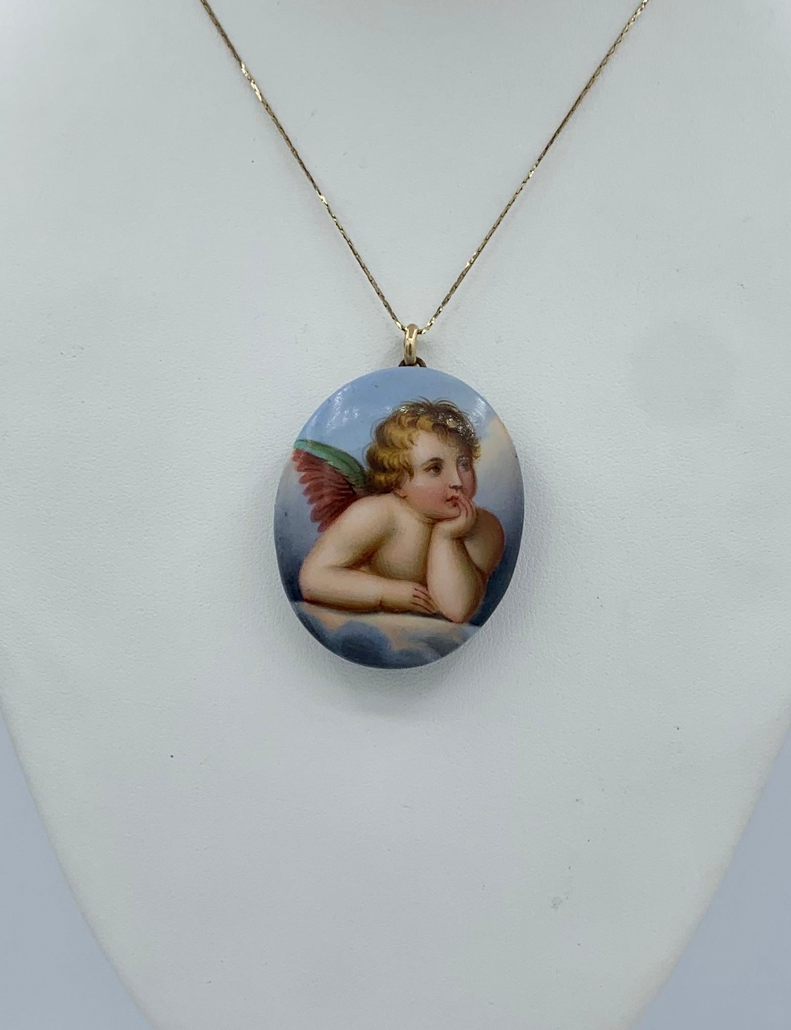 Dies ist eine sehr seltene und wunderbare viktorianische Medaillon Anhänger mit einem handgemalten Bild von Raphael's Winged Cherub oder Engel in den Himmel mit Wolken.  Das romantische und charmante Bild ist wunderschön von Hand auf Porzellan