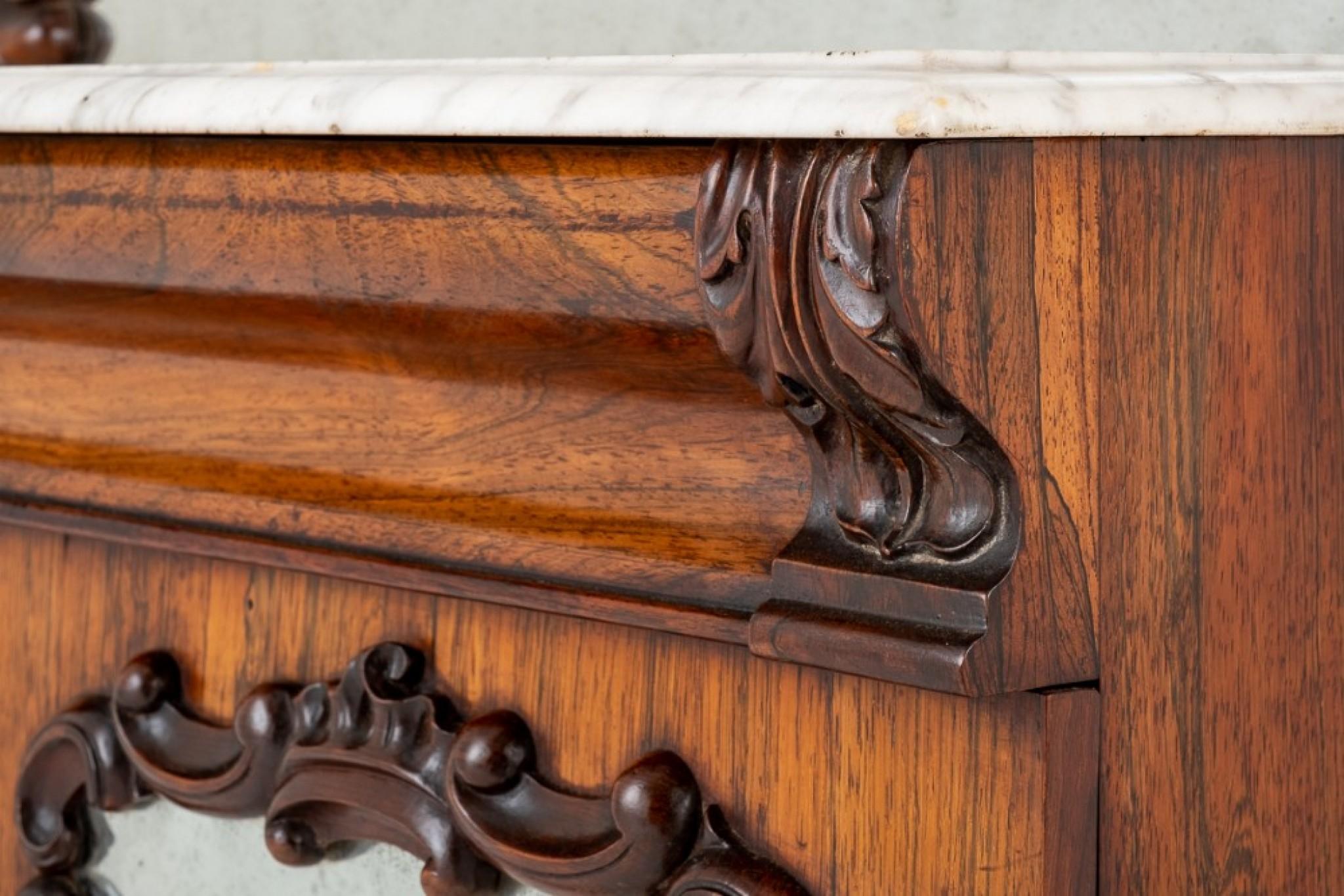 Rosewood marble top chiffonier.
Standing upon a plinth base.
circa 1860
The lower doors being of a mirrored form with carved decorations.
The doors open to reveal 1 interior shelf.
Above the doors there is a mahogany lined shaped drawer.
The
