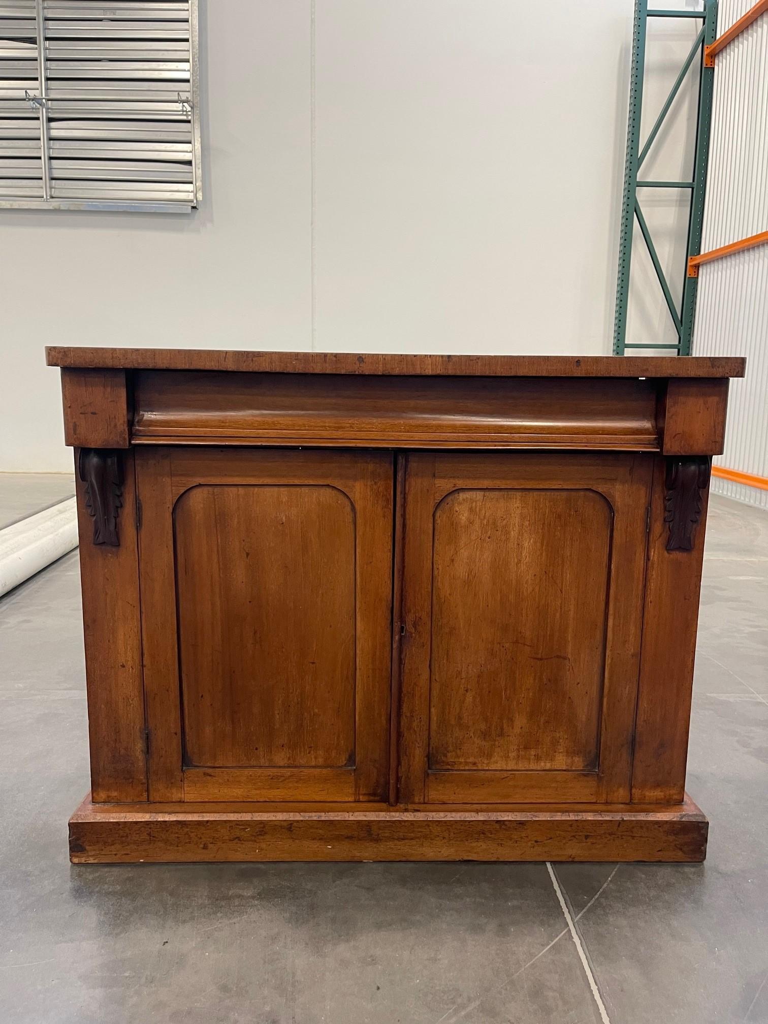 An antique Victorian 19th century mahogany chiffonier base sideboard / server. Of rectangular form with single shaped drawer twin cupboard doors and shaped molding, the interior opens up to one shelf. The chiffonier is raised on a plinth base.