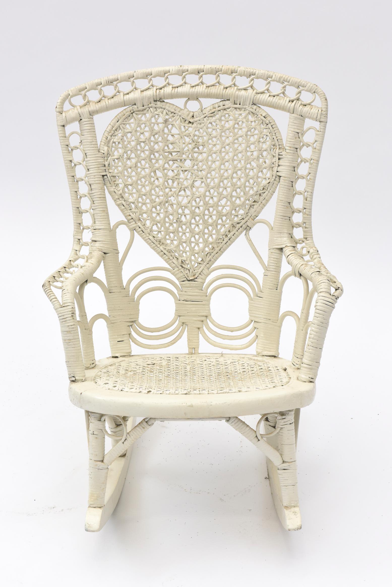 A fine example of spider woven wicker, this early Victorian wicker chair is a charmer. It has a cane seat and interwoven circles going up the arms and across the top of the back. This delightful child's rocking chair would be a perfect addition to a