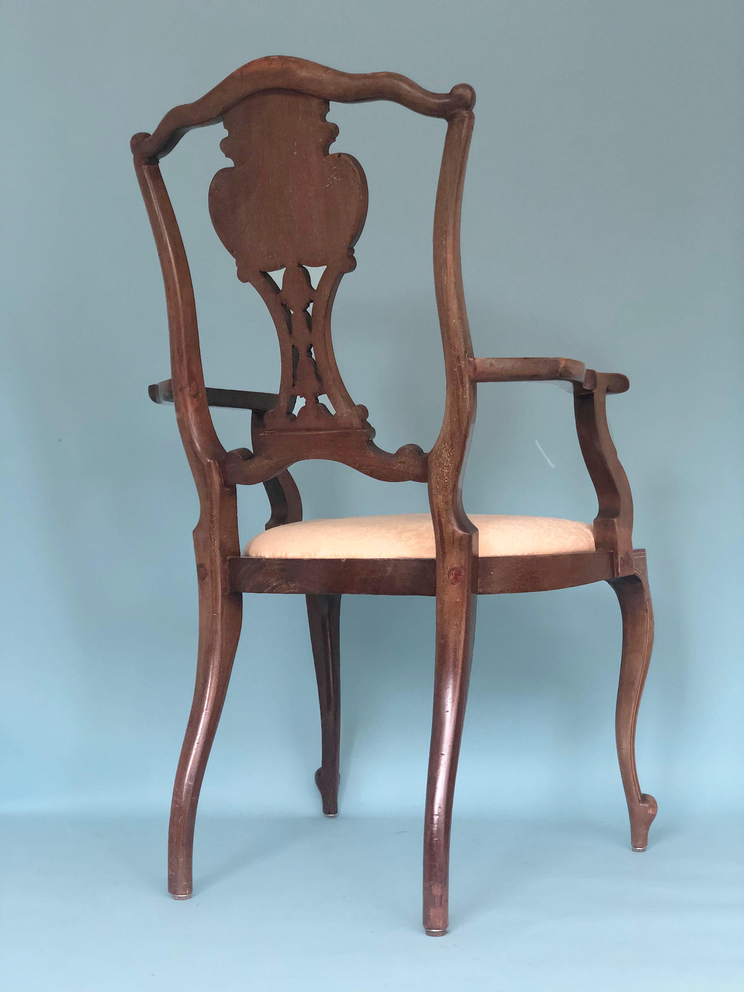 A Victorian Chippendale Revival armchair in mahogany from the late 19th century. The handmade decoration in the back has a mosaic of inlaid bone and satinwood. The seating is covered with a cream fabric with a pattern.

Object: Armchair
Design: