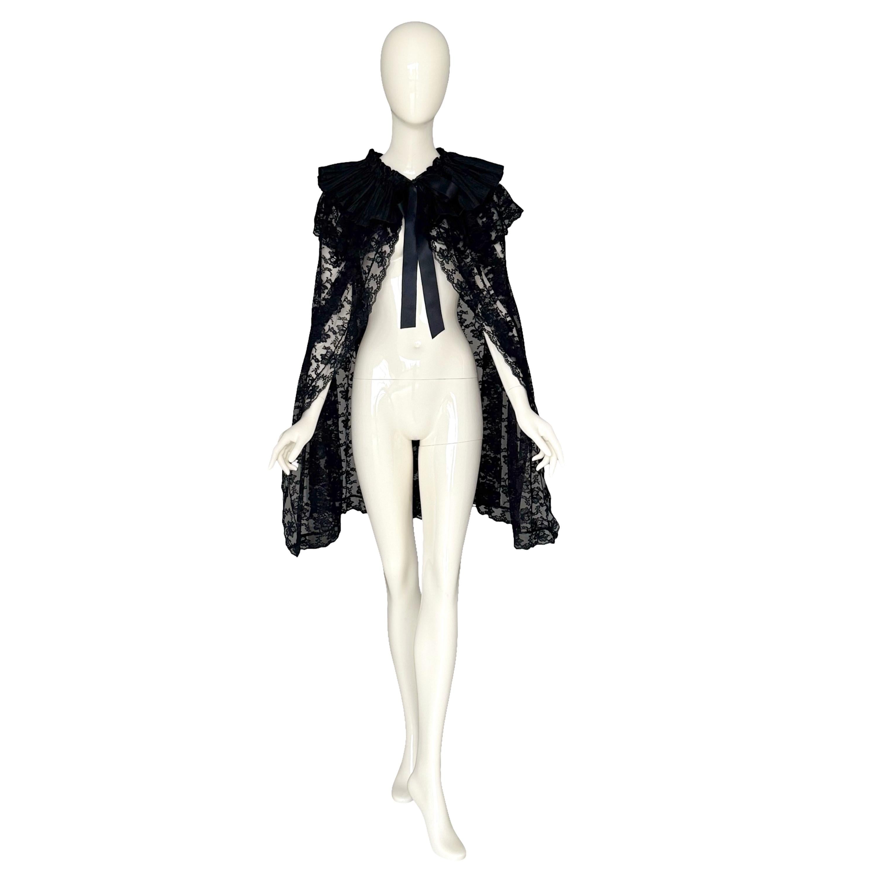 Original Victoriana Circa 1880s 1890s Capa de Encaje Negra con Cuello de Raso
Se trata de una auténtica capa de la época victoriana, confeccionada con delicado encaje Chantily floral negro, con cuello de raso plisado y lazo de cinta. Es una