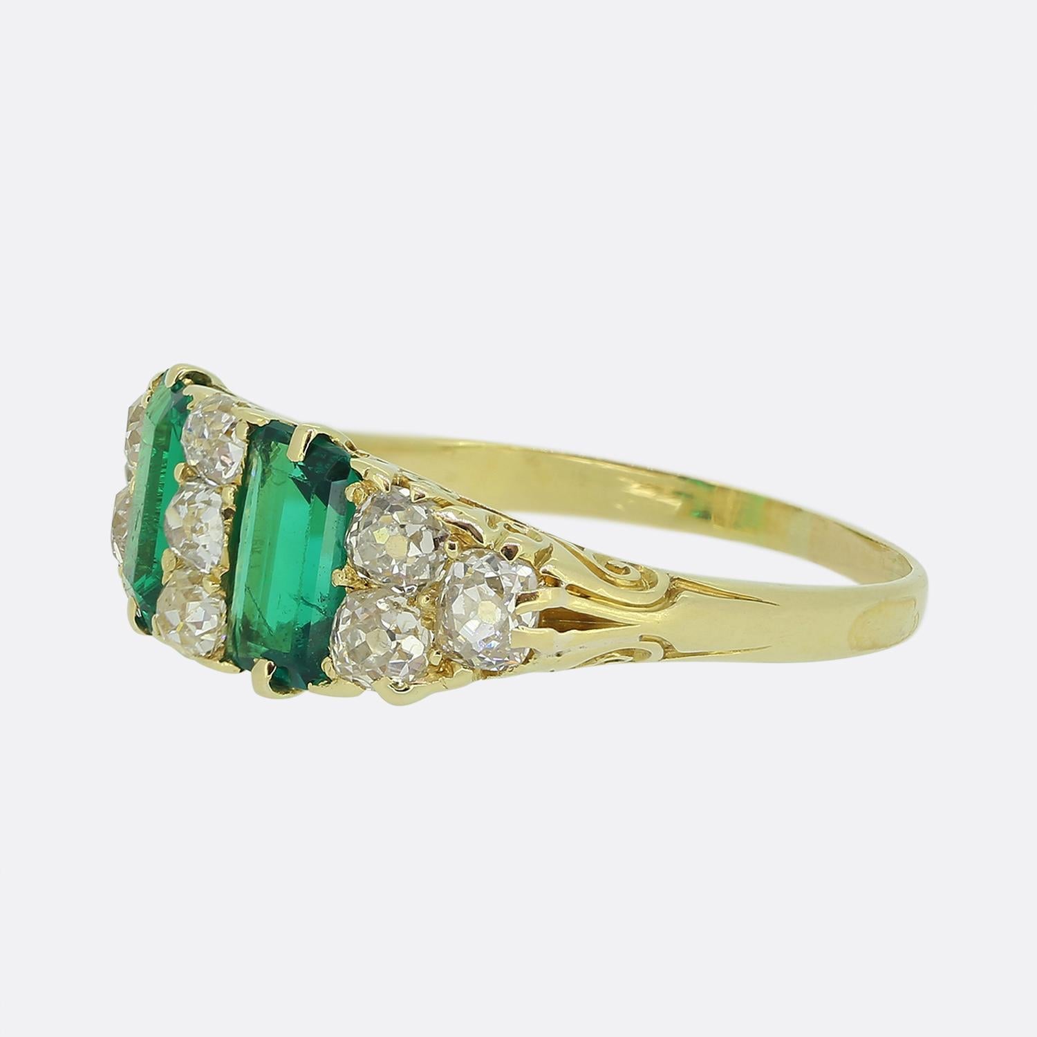 Ecco uno squisito anello vittoriano a grappolo dal design sorprendente. Al centro troviamo due smeraldi verdi rettangolari incastonati in verticale e affiancati da una serie di diamanti rotondi sfaccettati di vecchio taglio. Lo splendore dei