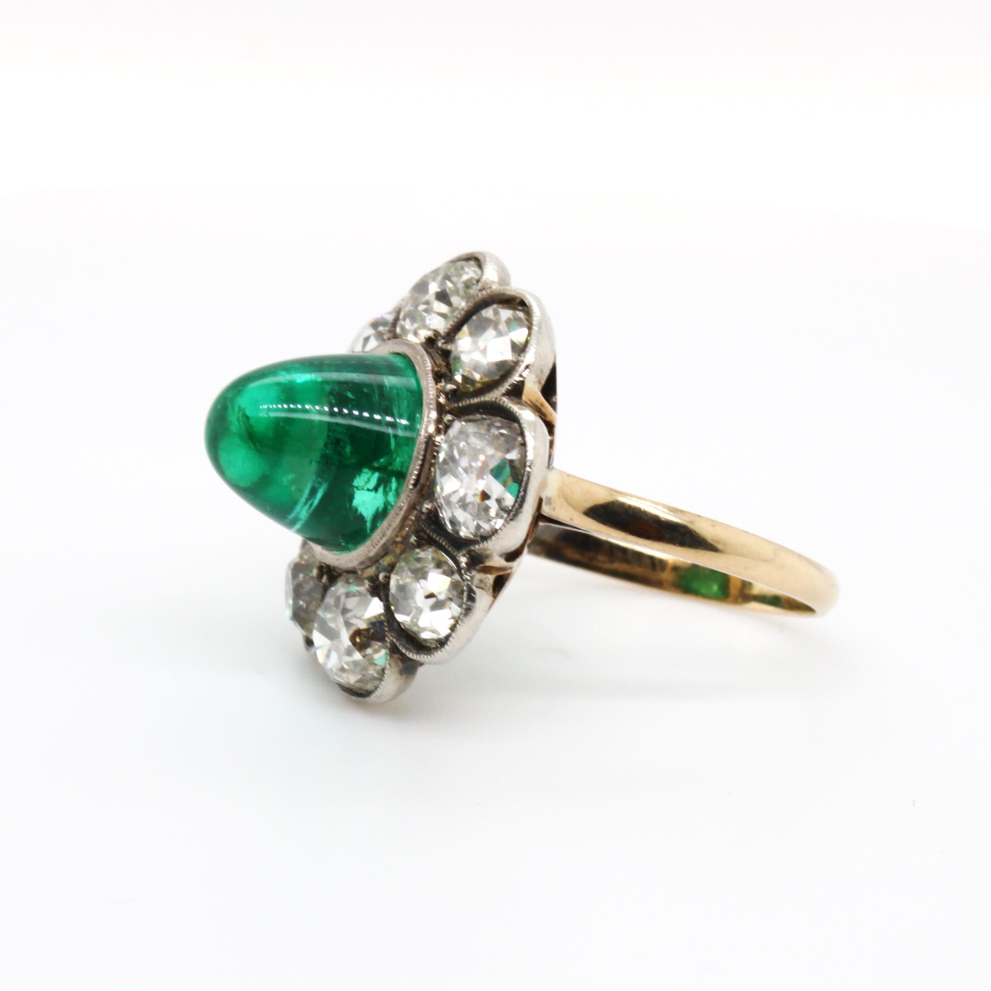 Victorian Colombian Cabochon Emerald and Diamond Ring, ca. 1880s

The beautiful Victorian high cabochon emerald (ca. 6.5 carats, Colombian) is a very clean and bright stone with a beautiful crystal. It is surrounded with petals of old European cut