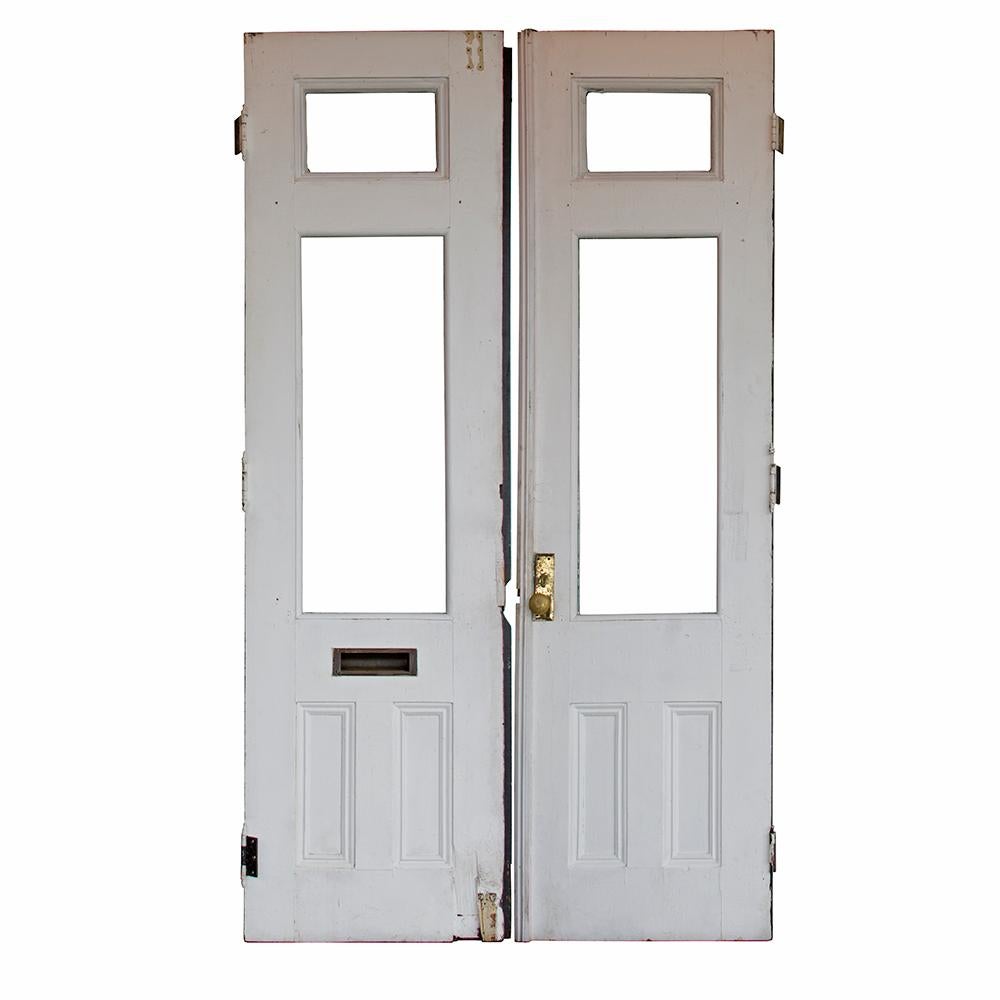 A perfect pair, these substantial commercial doors have a few fun details to make them stand out in the crowd. Lower recessed panels are accented with bullseye corners and each door has an upper transom for additional light. Original hardware