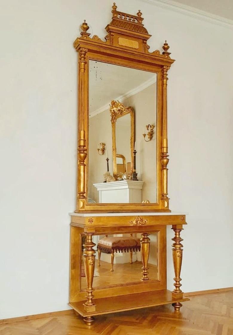 In this listing you will find an exceptional console table with an extra large mirror sitting a top of its marble top. It is done in Late Victorian style and made in Austria around 1880s. The console table and the mirror are done in gold plated