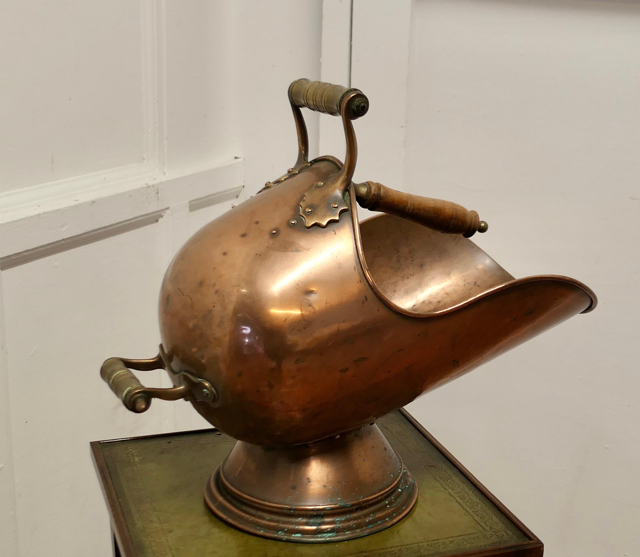 Victorian Copper Helmet Coal Scuttle 

This bucket is a very attractive Enclosed Oval shape, it is made in hand beaten Copper with two handles, with a shovel and carrier on the inside 
The Scuttle is in good used condition, it has no faults just