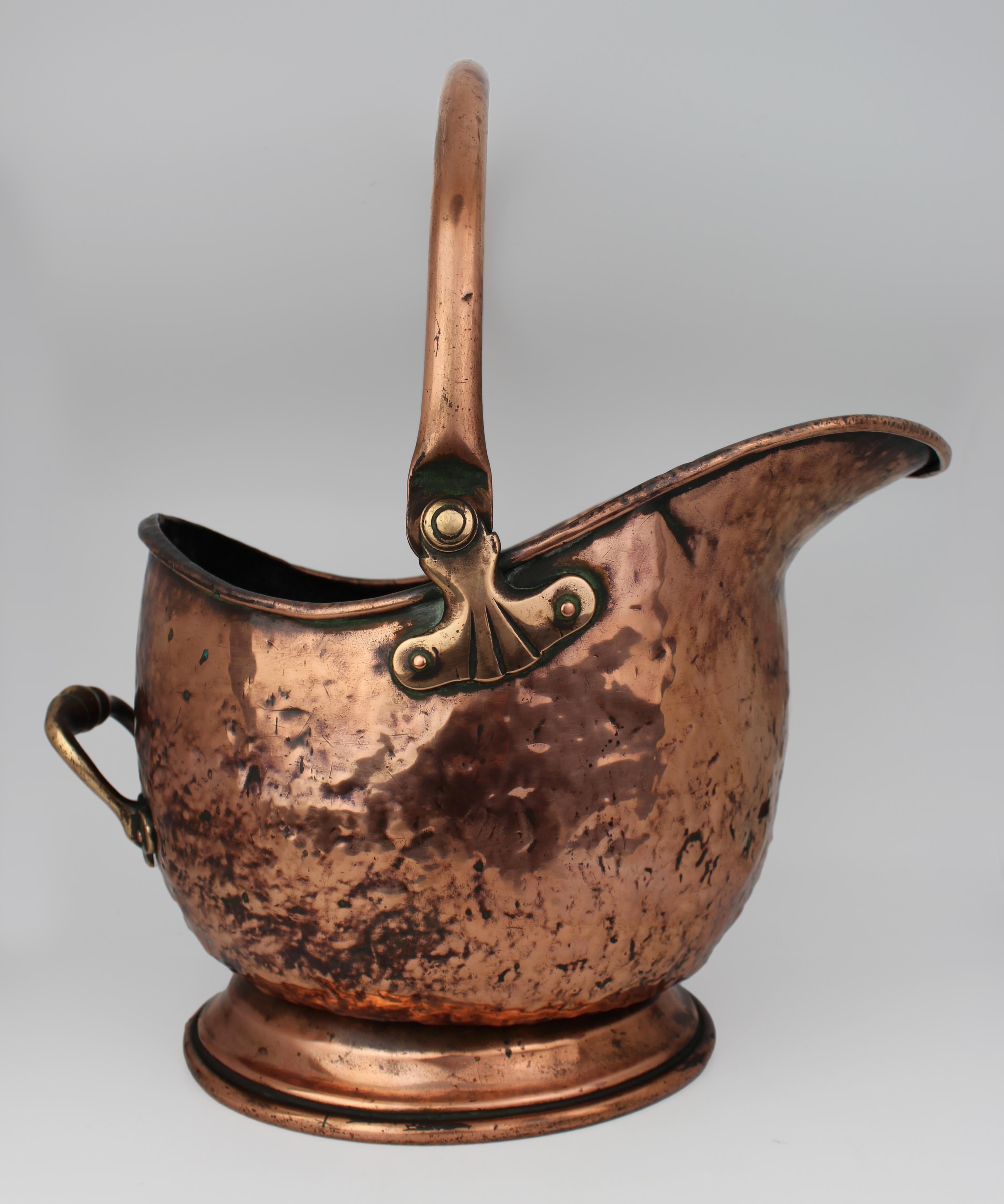 Carbonera victoriana de casco de cobre con monturas de latón, Inglaterra, S. XIX

Preciosa carbonera inglesa de cobre del siglo XIX con forma de casco, ricamente patinada y montada con asas giratorias y traseras de latón. Esta elegante pieza para la