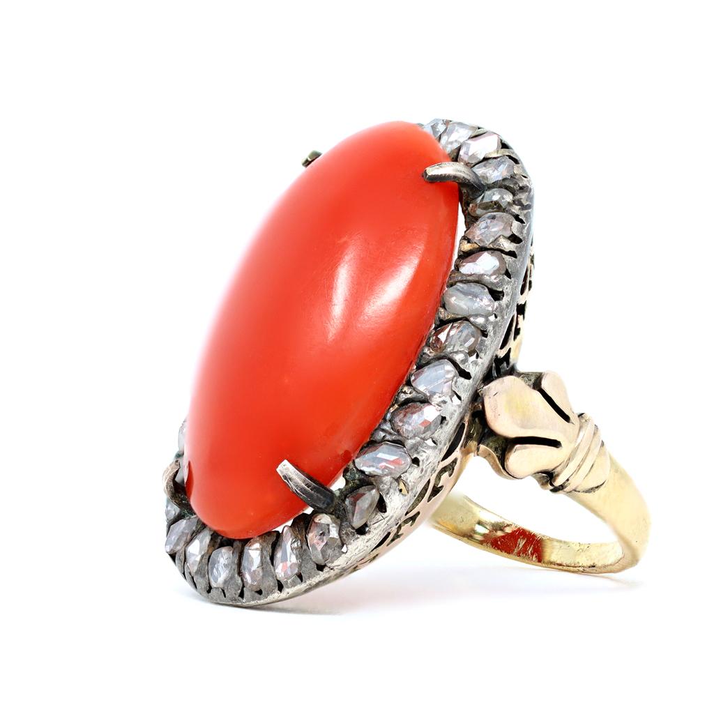 Dies ist ein Vintage-Ring aus tiefrotem Korallen-Cabochon, der mit Diamanten im Rosenschliff verziert ist. Die frühe Handarbeit, ein Zeugnis der geschickten Kunsthandwerker der Vintage-Ära, zeigt sich in der auf Gold geschmolzenen Silberplatte.