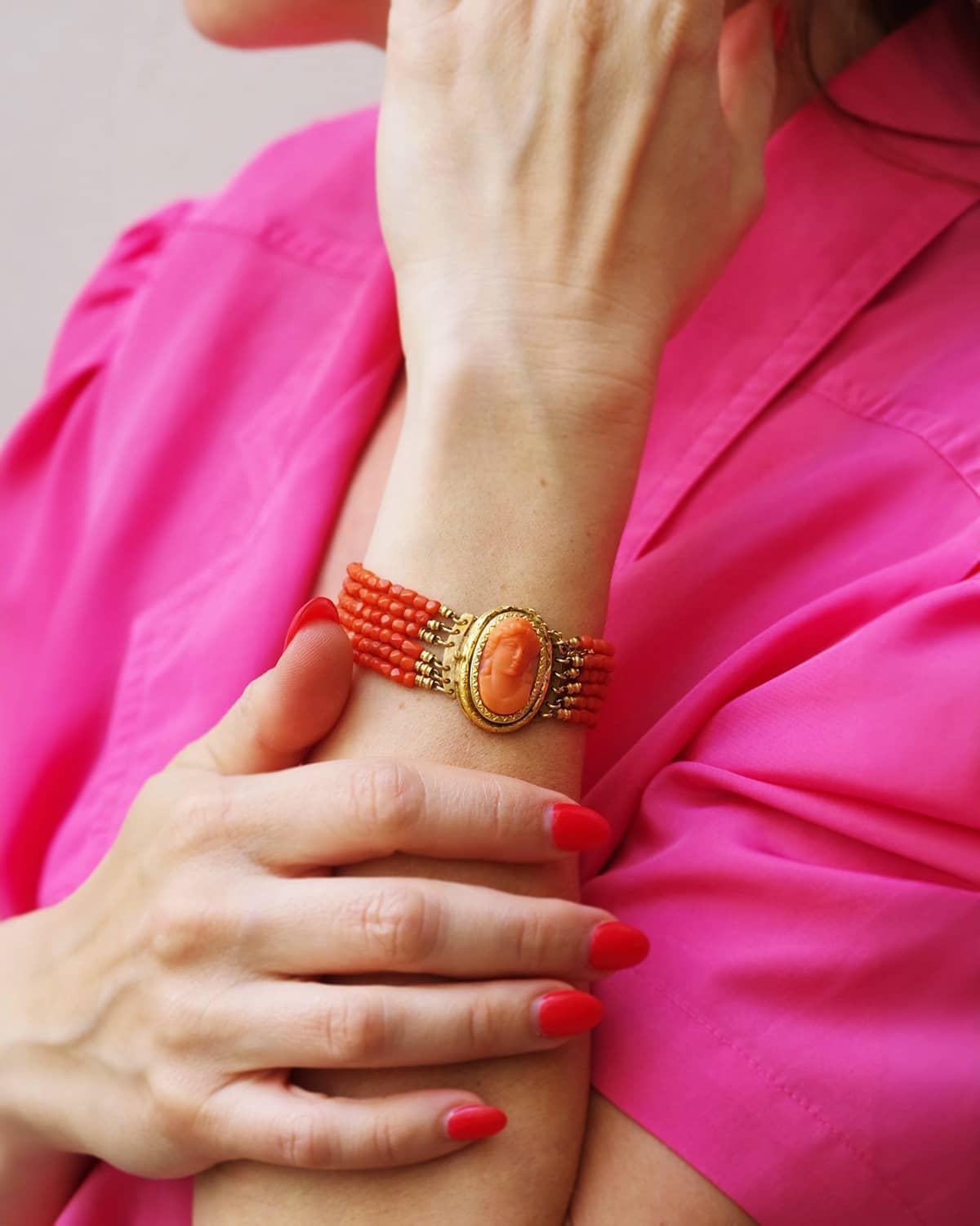 Victorian coral cameo bracelet in 18 karat gold. Bracelet composed of 6 rows of faceted coral beads. The clasp is a ratchet box, decorated with an oval cameo depicting an antique woman, wearing a Roman hairstyle. This piece of jewelry is of