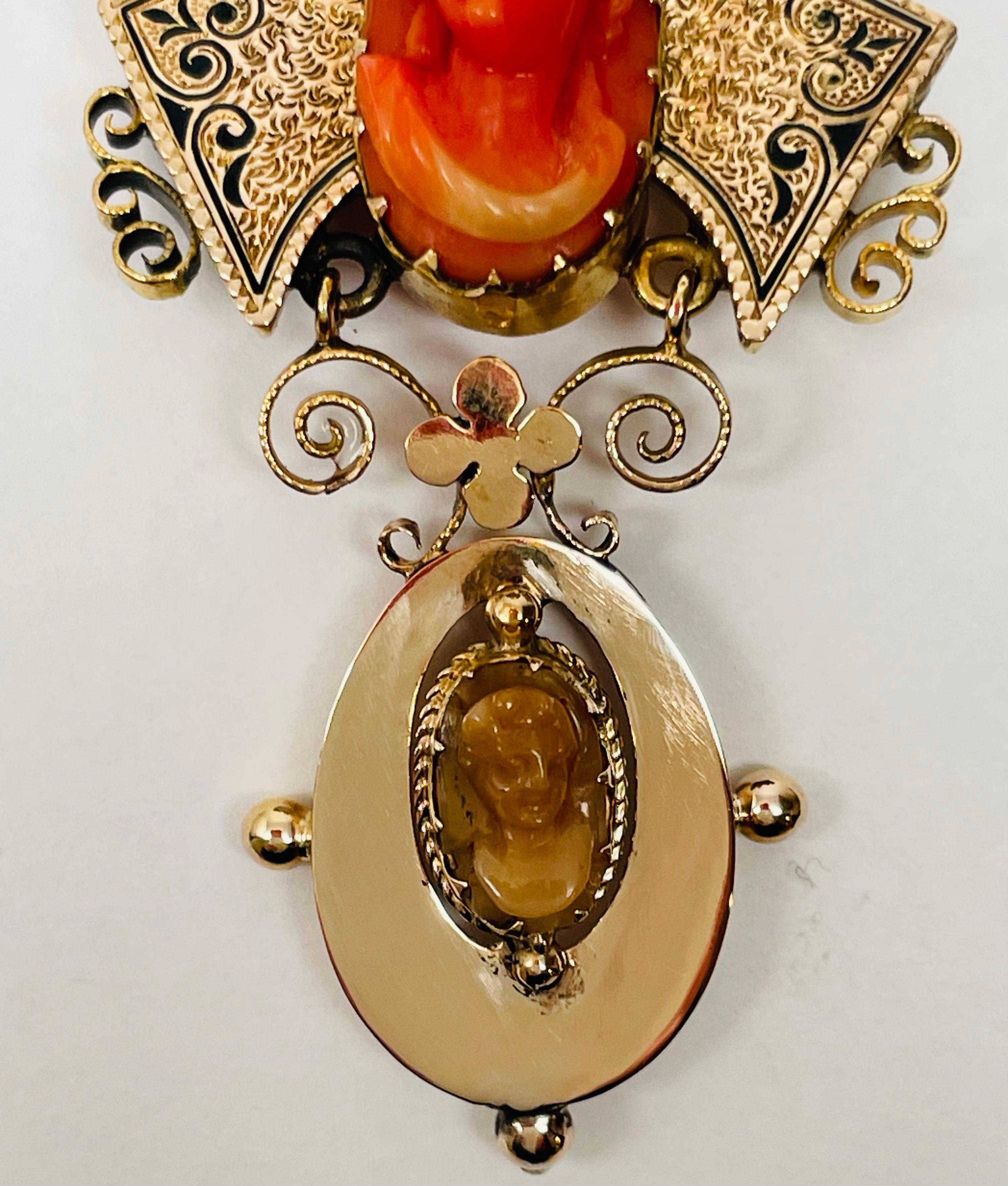 Very unusual Victorian 14kt. Gold Brooch with 2 cameos. The upper portion has taille d’epargné, engraving filled in with black enamel. The cameo on the upper piece is a high relief woman's face carved from Coral. The smaller cameo on the hinged
