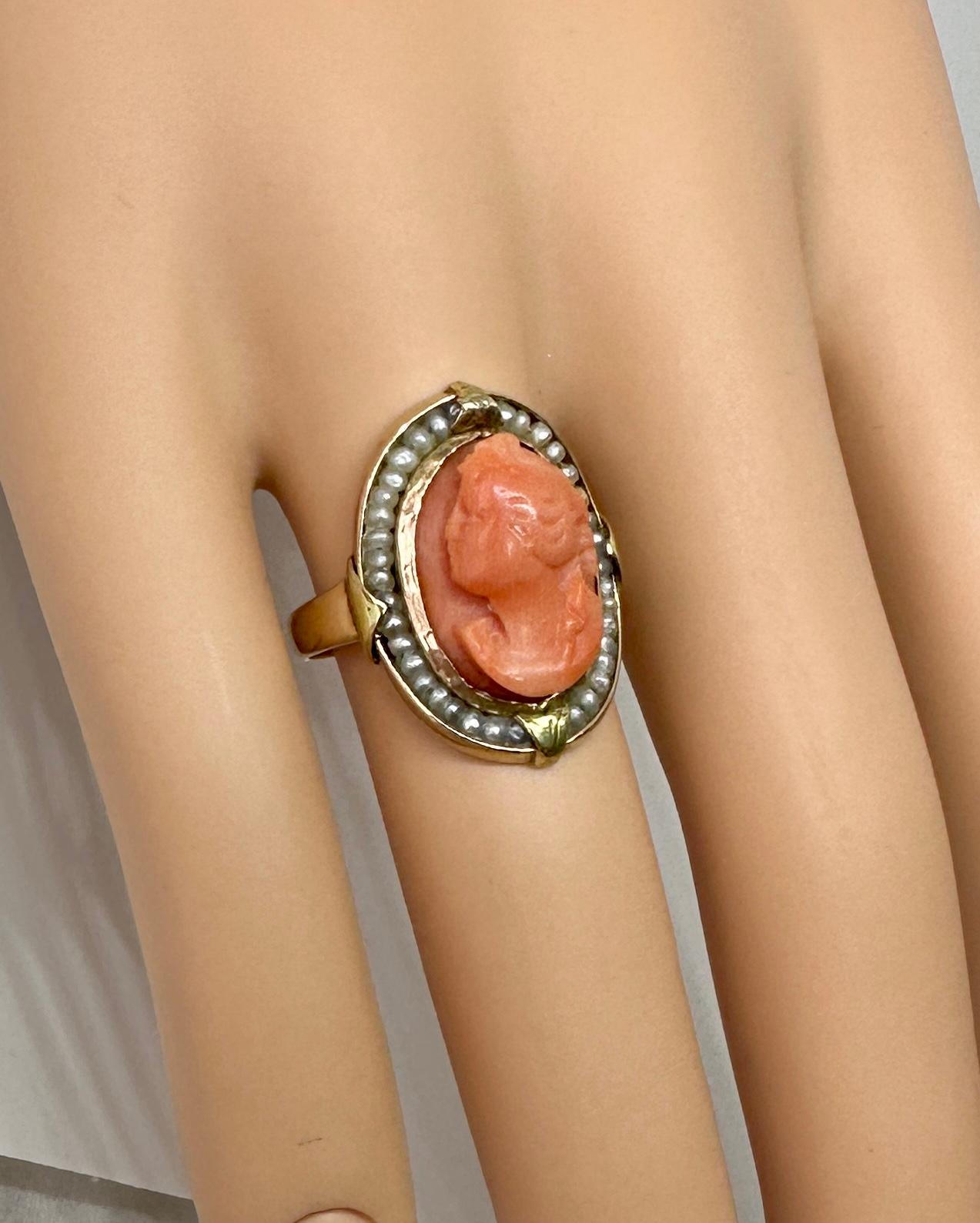 This is an absolutely stunning and rare antique Victorian - Belle Epoque Coral Cameo Ring with a hand carved image of a classical goddess woman set in a gorgeous 14 Karat Yellow Gold frame with a halo of Seed Pearls.   Coral cameos are very rare and