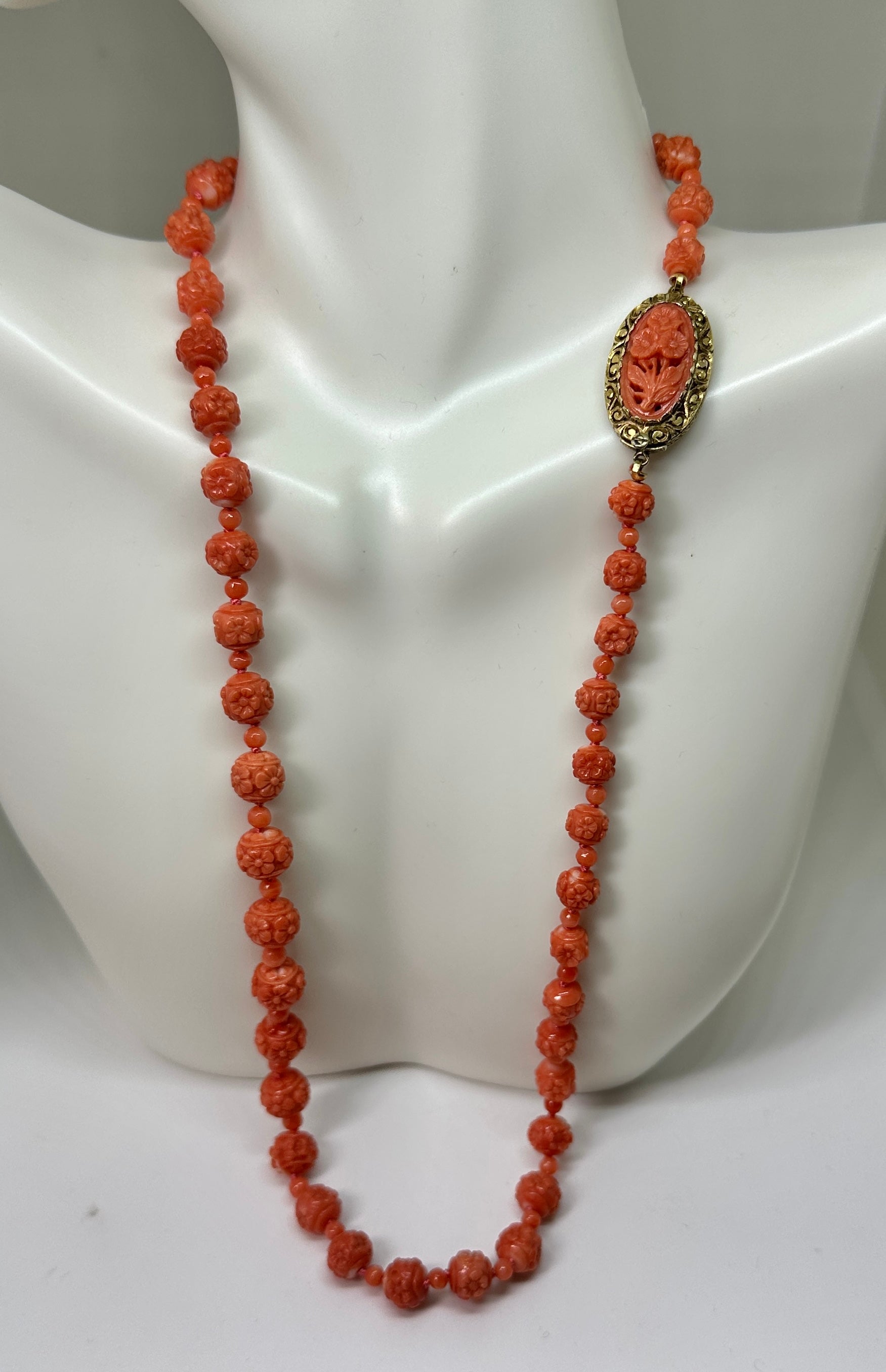 Indulge in a magnificent and very rare Antique Victorian - Art Deco Coral Necklace of graduated hand carved Coral Beads with Forget Me Not Flowers carved around each bead and with a stunning carved floral clasp in 18 Karat Gold.  The clasp depicts