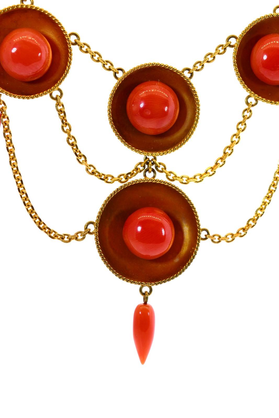 This coveted unique stunner is created in 15KT yellow gold.  The English beauty sports 8 discs each with a deep salmon color Coral button.  Seven tear shaped cords add movement to this already supple, gorgeous 17 1/4 inch long necklace.  Circa 1890s.