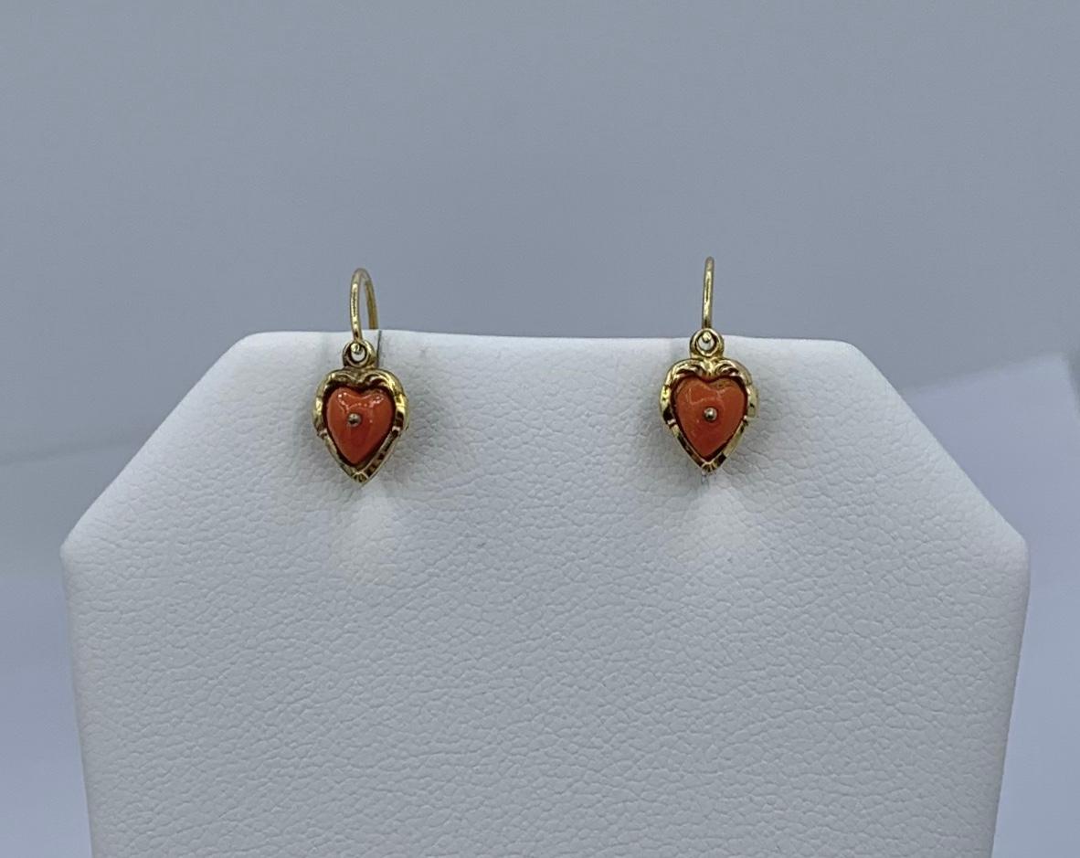 This is a gorgeous pair of Victorian Coral Heart Dangle Drop Earrings in 10 Karat Gold.  The wonderful dangle drop earrings have delicate hand carved coral hearts.  The hearts are set in a repousse engraved heart setting in 10 Karat yellow gold. 