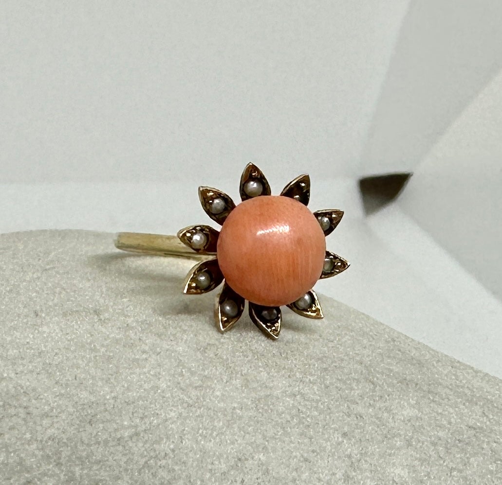 This is a wonderful early Victorian Flower Ring with a central natural Salmon Coral Cabochon with Pearls set in the petals of the leaves.  The daisy motif ring is 9 Karat Gold.  The beautiful Victorian ring is charming and delightful and a very rare