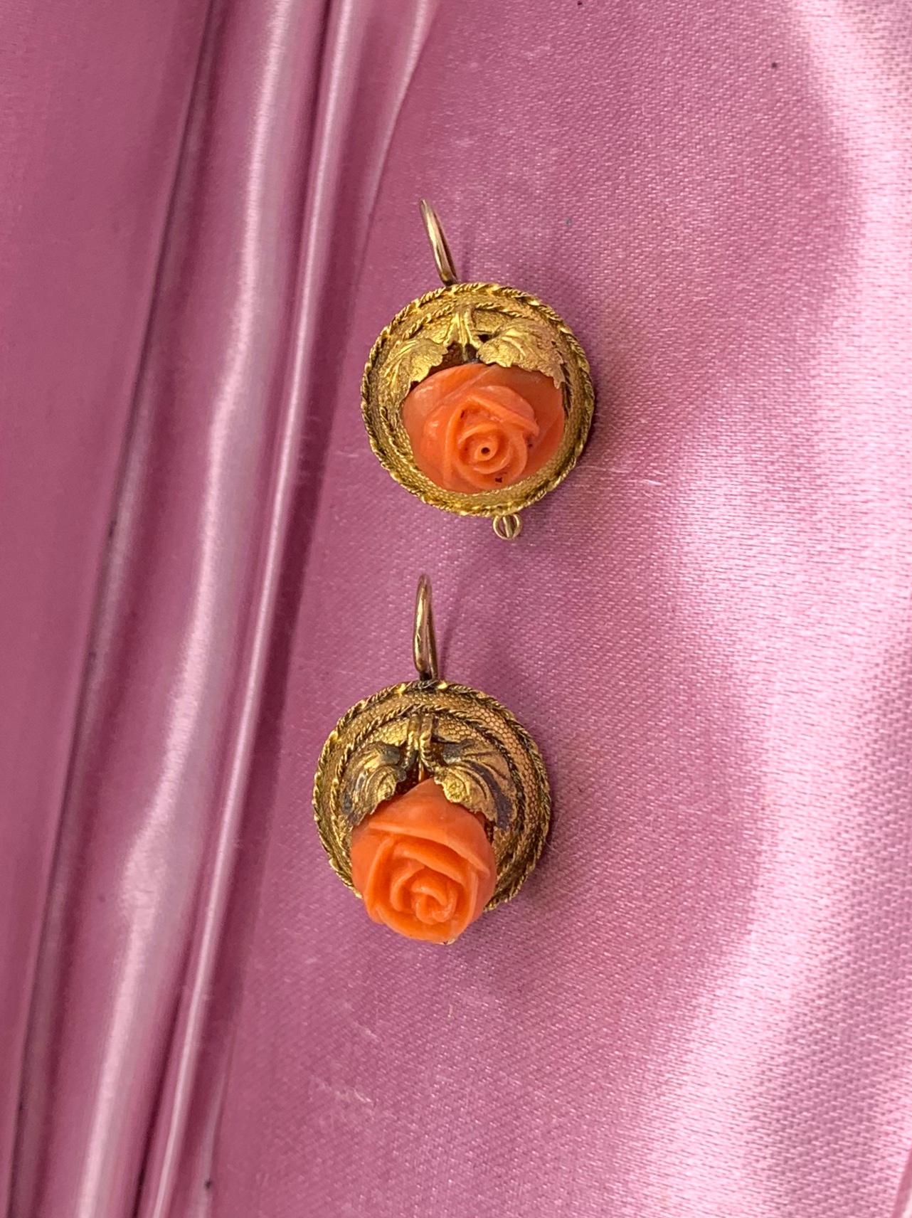 Une paire rare de boucles d'oreilles victoriennes en or 14 carats, de style néo-trusque, avec des roses de corail.  Les boucles d'oreilles sont ornées de fleurs roses tridimensionnelles sculptées à la main dans du corail saumon naturel.  La