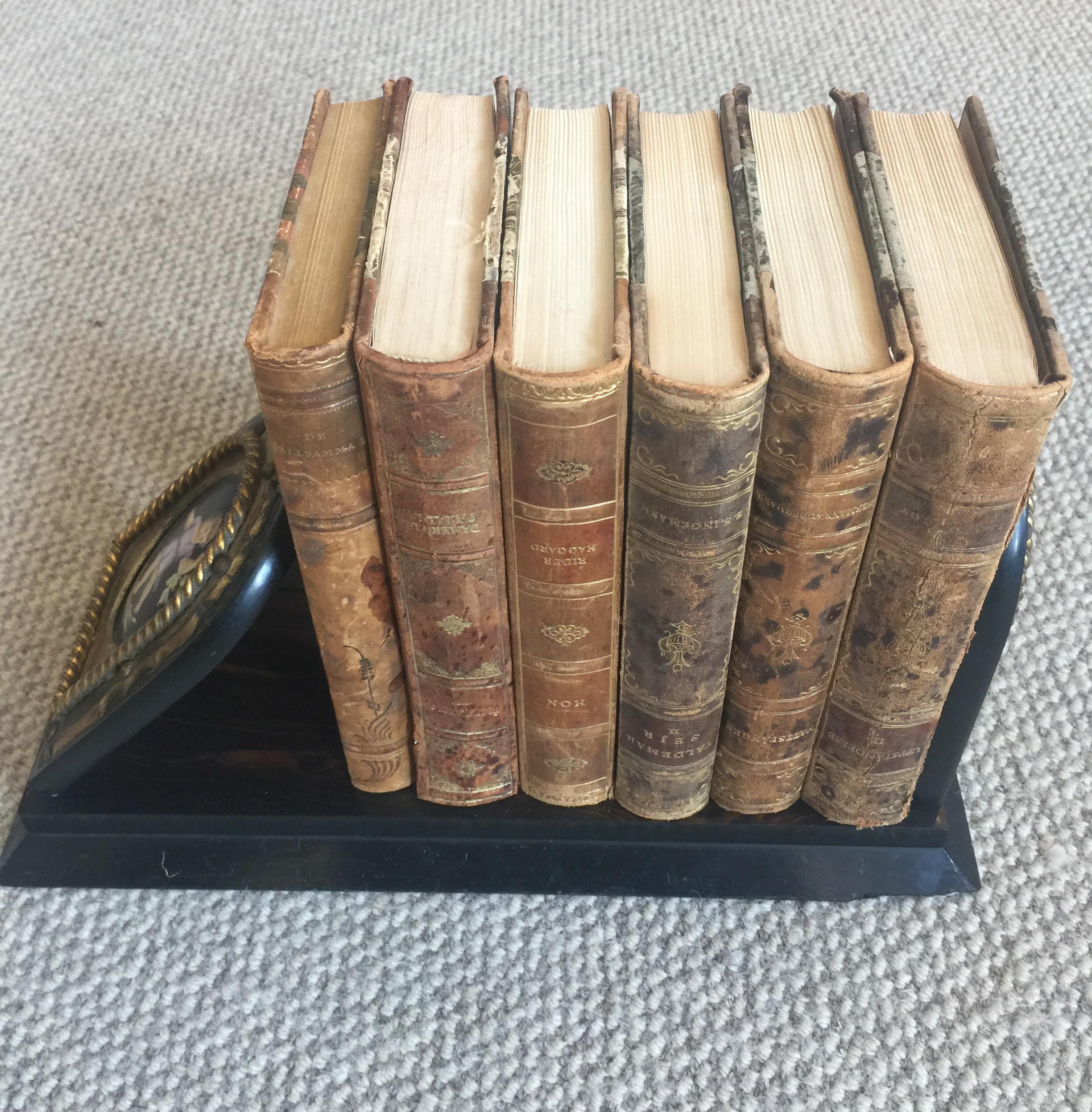 A beautiful Victorian brass-mounted coromandel book rack with inset hand painted cherub porcelain plaques. Brass retailers plate for 