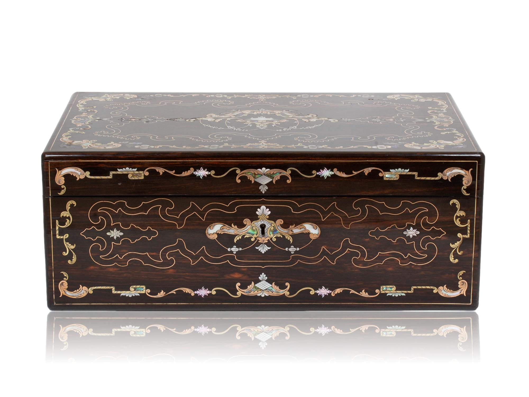 Kostenloser weltweiter Versand

Starke Intarsienarbeit mit Perlmutt, Abalone und Messing

Aus unserer Writing Box Kollektion bieten wir Ihnen diese fantastische Coromandel Inlaid Writing Box von Hausburg an. Das rechteckige, in Coromandel furnierte