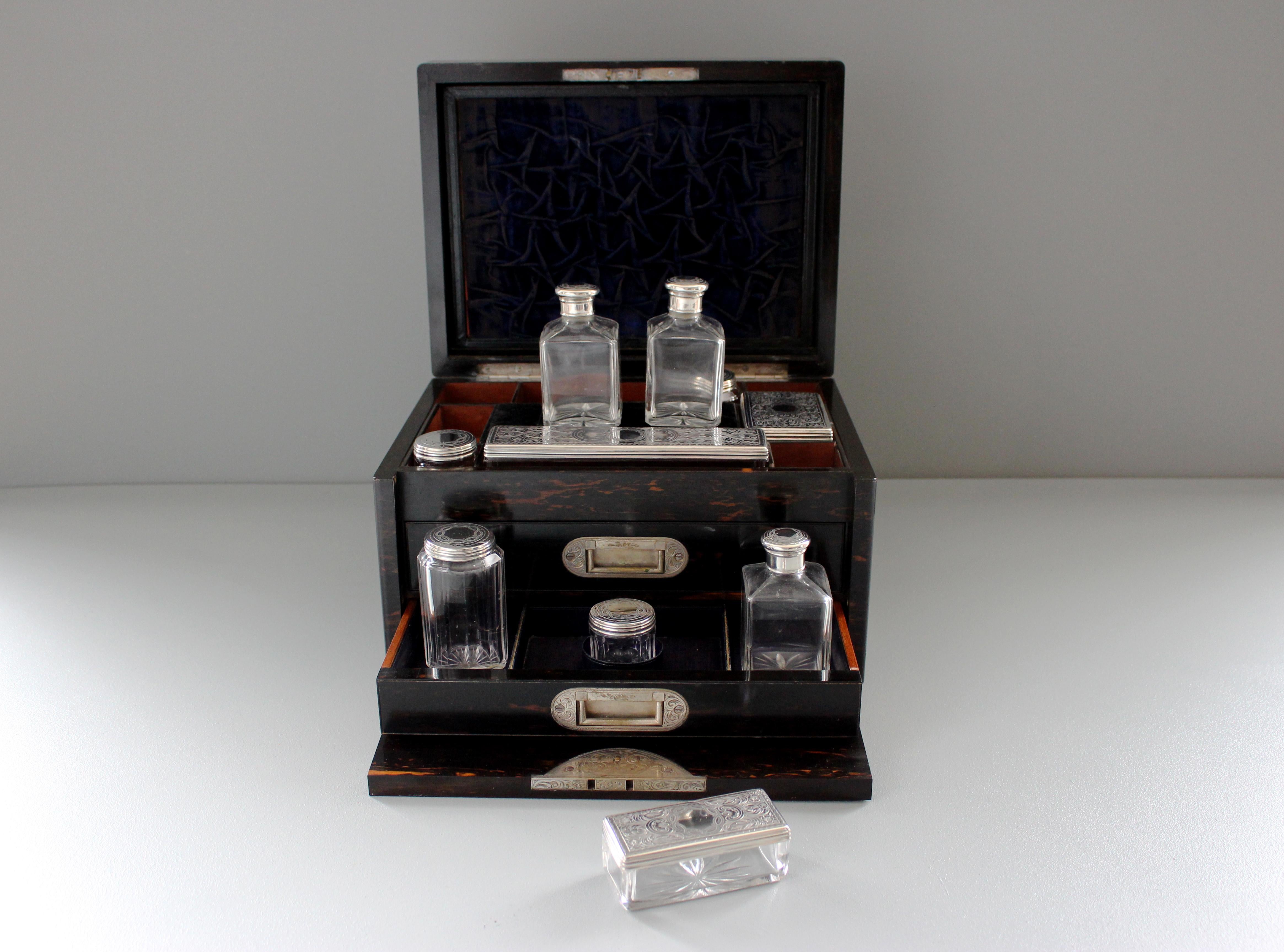 A Victorian calamander toilet box with ten silver mounted jars, by William Neal, London, dated 1874. The box with fall front, two drawers and secret drawer, three jars unmarked, the total weight of the silver lids 152 grams (4.89 troy ounces).