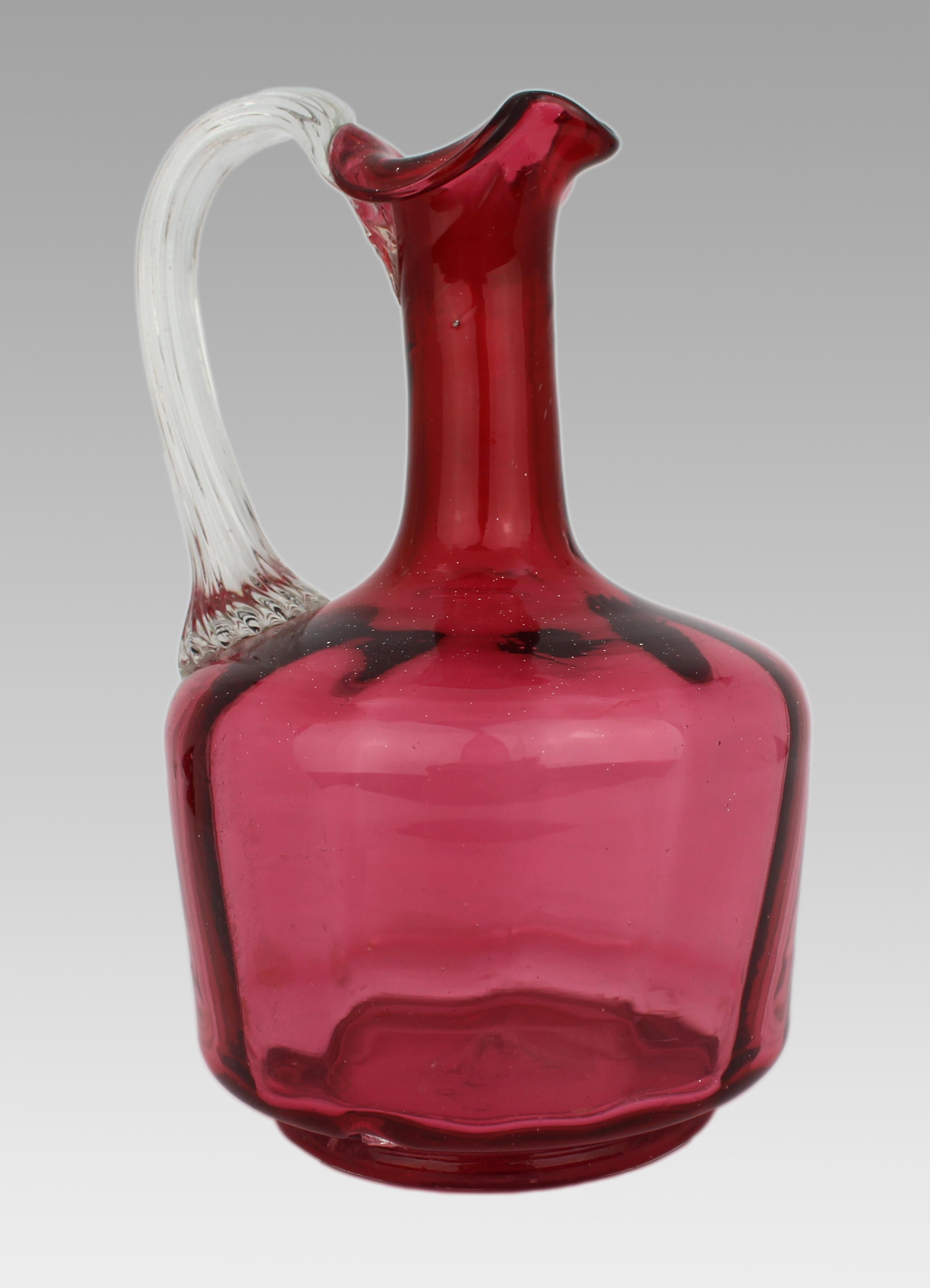 Victorian Cranberry Glass Jug

A good quality Victorian hand-blown cranberry glass jug.

The jug of rich cranberry glass, with an applied clear glass handle of reeded form and decorative lower terminal. Shaped pouring lip. The base with snapped