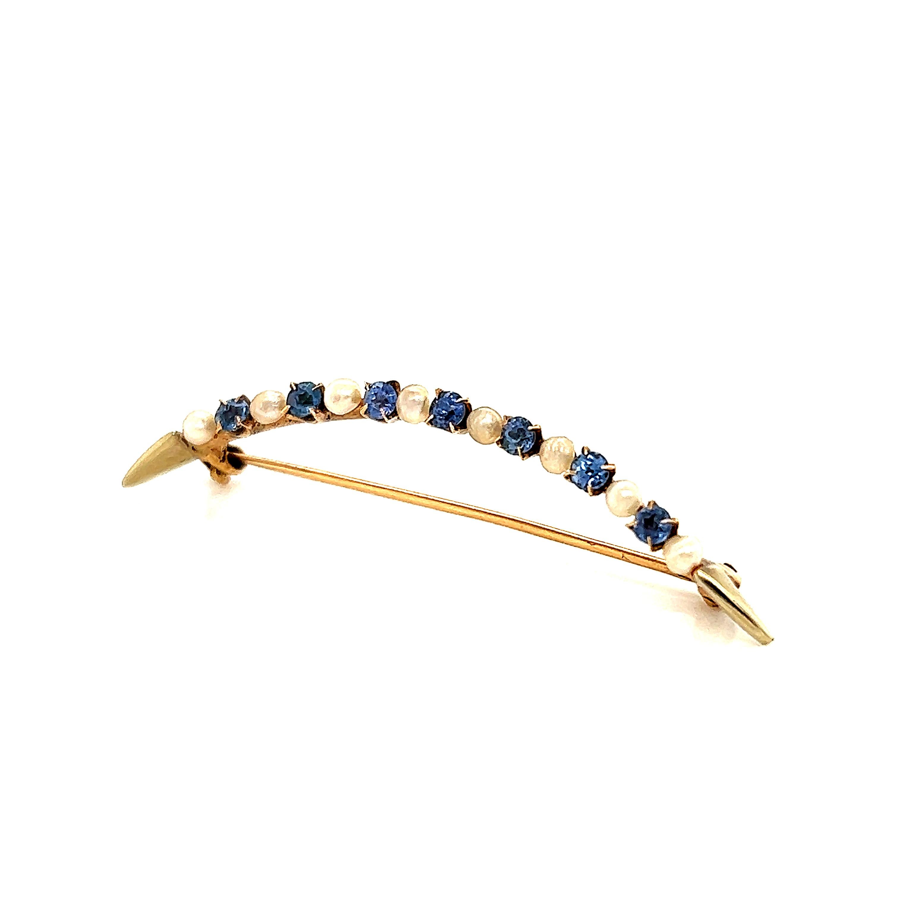 Gorgeous Victorian brooch crafted in 14k yellow gold. The brooch is crafted in the crescent moon shape set with natural seed pearls and sapphires. The crescent moon celebrates the feminine moon goddess and therefore is associated with female