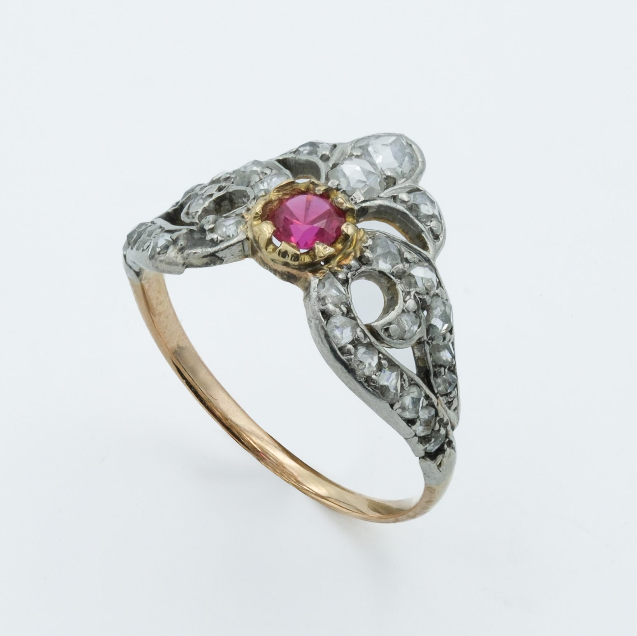 This Victorian-era ring presents a stunning combination of 18 karat rose gold and platinum, a testament to the period's craftsmanship. The ring features a central synthetic ruby, approximately 0.1 carat, set in a rich yellow gold bezel. This ruby is