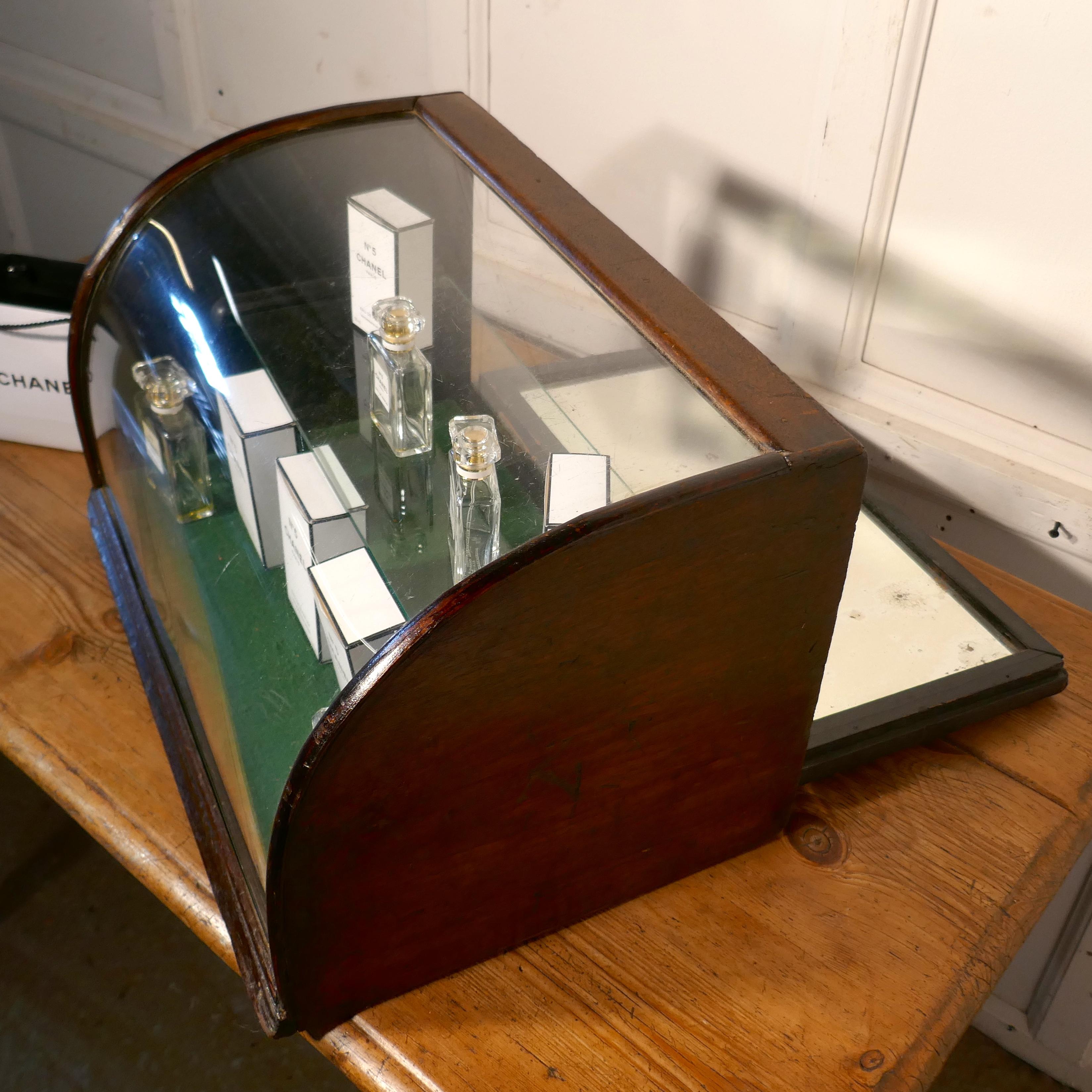Victorian curved, mirrored shop display cabinet.

The cabinet is a counter top piece, it made in mahogany and has a curved front surface, with a mirrored door at the back, giving plenty of reflected light, it has green baize on the floor and a