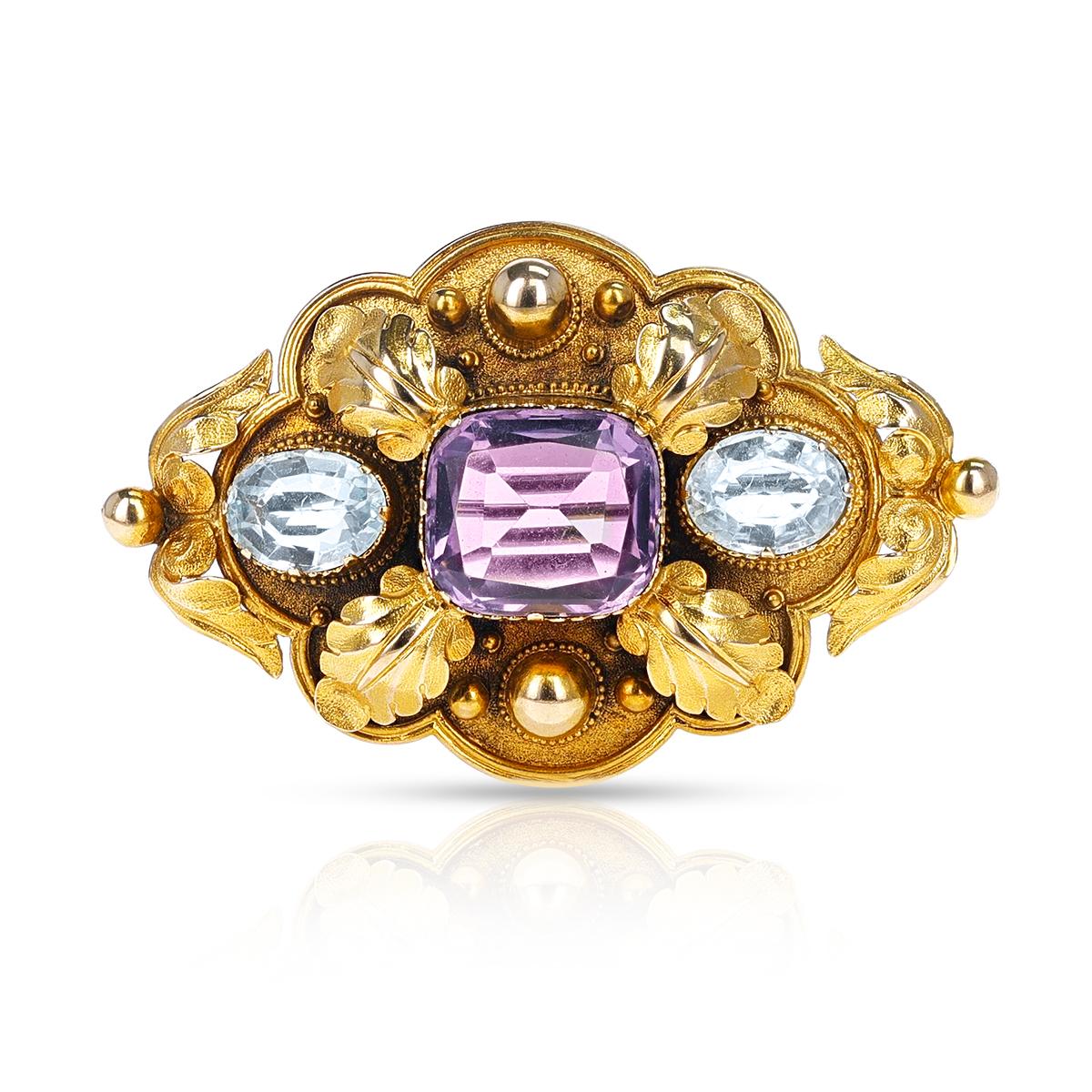 A Victorian Cushion Amethyst and two Oval Topaz stones Brooch made in 18k Gold. There is no gold mark but it has been tested. The weight of the brooch is 11.10 grams. The dimensions are 2 inches x 1.25 inches. 

Amethyst Dimensions: 13.66 x 12.18 x