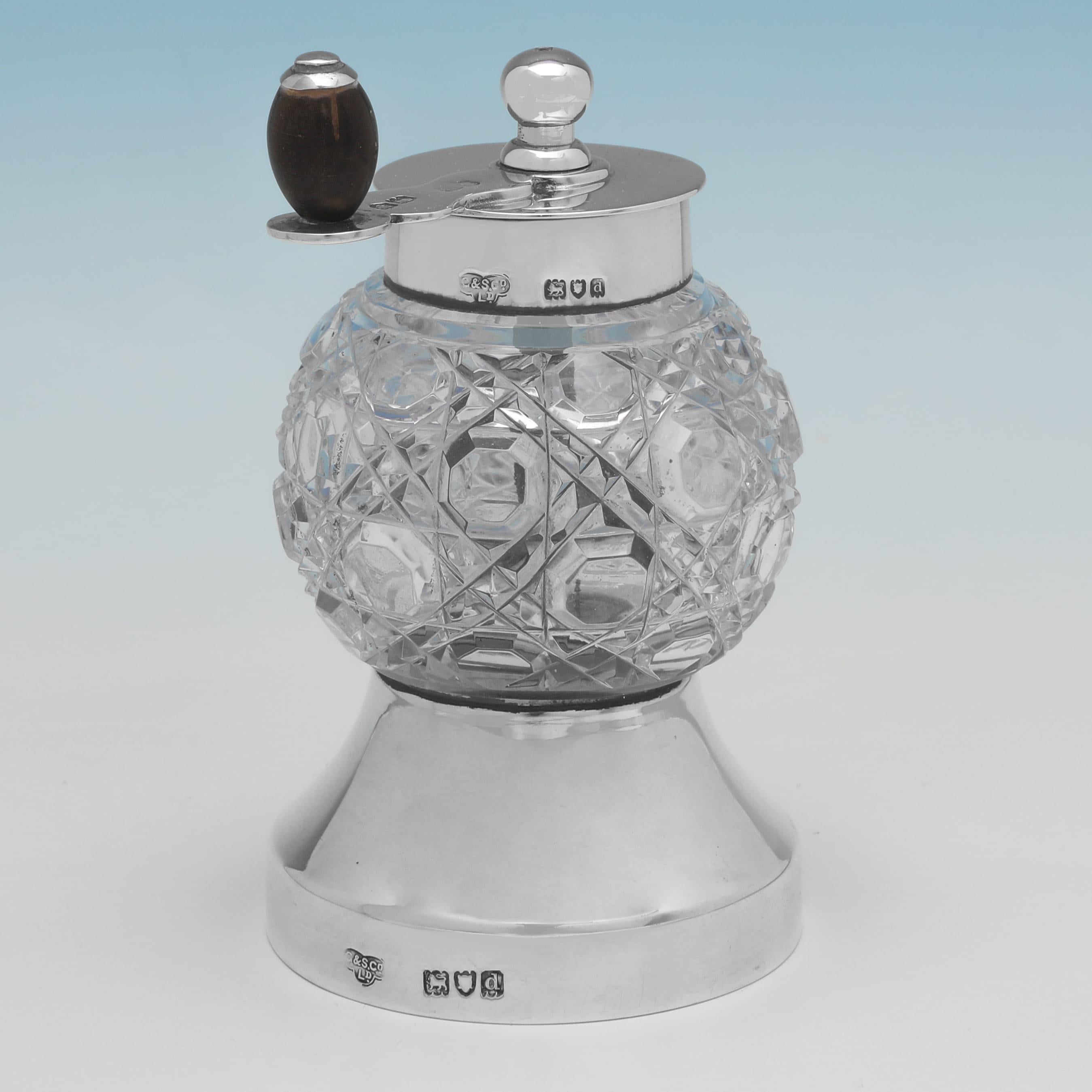 Hallmarked in London in 1899 by Goldsmiths & Silversmiths Co., this handsome, Antique, Victorian, Sterling Silver Pepper Grinder, features a round hobnail cut glass body, a plain silver base and top with handle, and a peugeot mechanism. The pepper