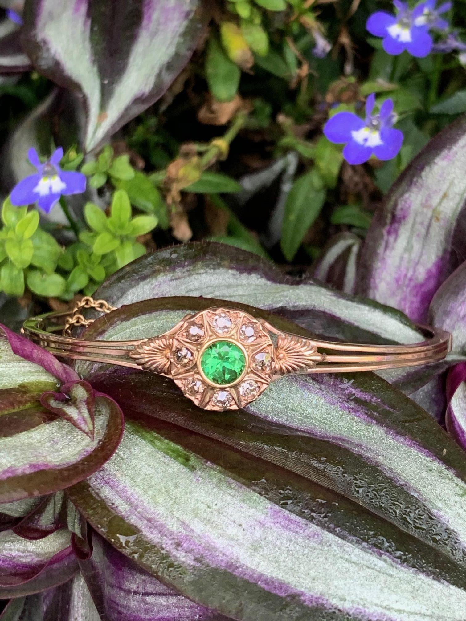 This antique Victorian Demantoid Garnet is set in 10 karat yellow Gold. The bracelet is hinged and has a box closure with safety chain.

It is stamped: 