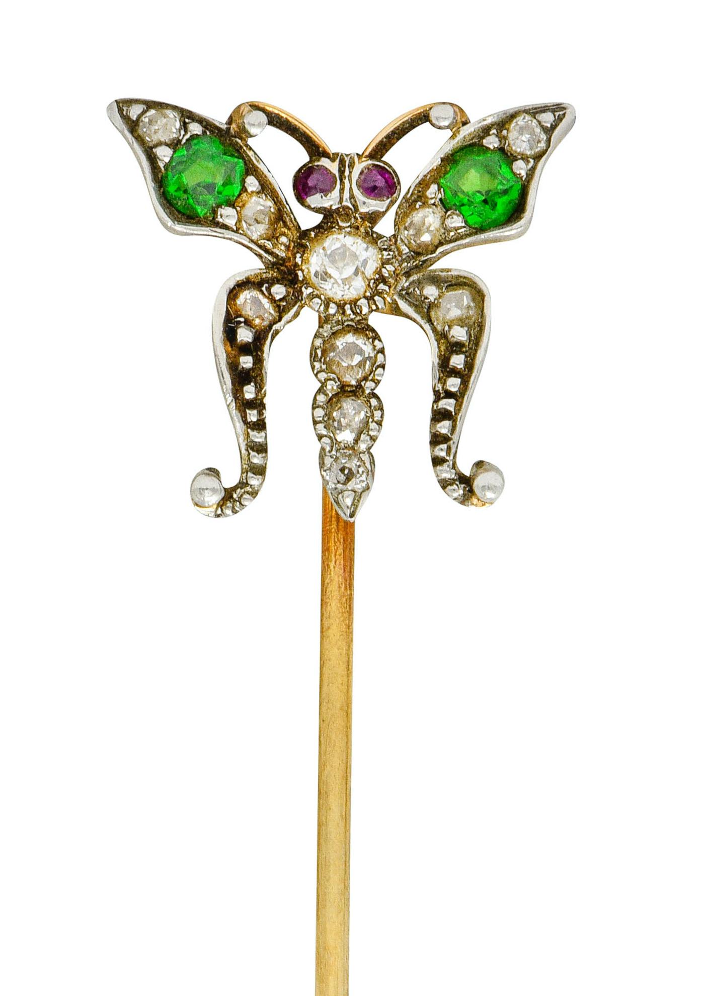 Designed as a stylized butterfly with ornately shaped wings, silver bead detail, and a segmented body accented by ruby eyes

Top wings are bead set with round cut demantoid garnet weighing approximately 0.22 carat total, bright lime green in