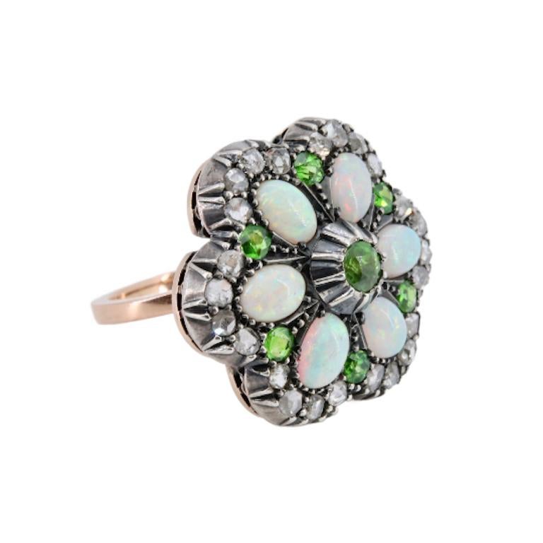 Aston Estate Jewelry Presents:

A beautiful victorian period flower form ring which also converts to a pendant. The flower is centered by a beautiful demantoid garnet of 0.40 carats, and further accented by six additional demantoid garnets of