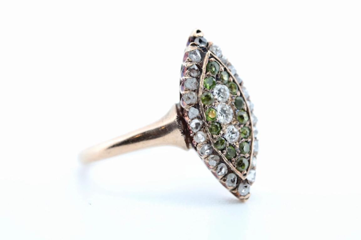 Aston Estate Jewelry Presents:

A victorian period Demantoid garnet, and rose cut diamond navette ring.

Centered by a trio of old mine cut diamonds of 0.20ctw. 

Encircled by a double halo of old mine cut demantoid garnets and rose cut