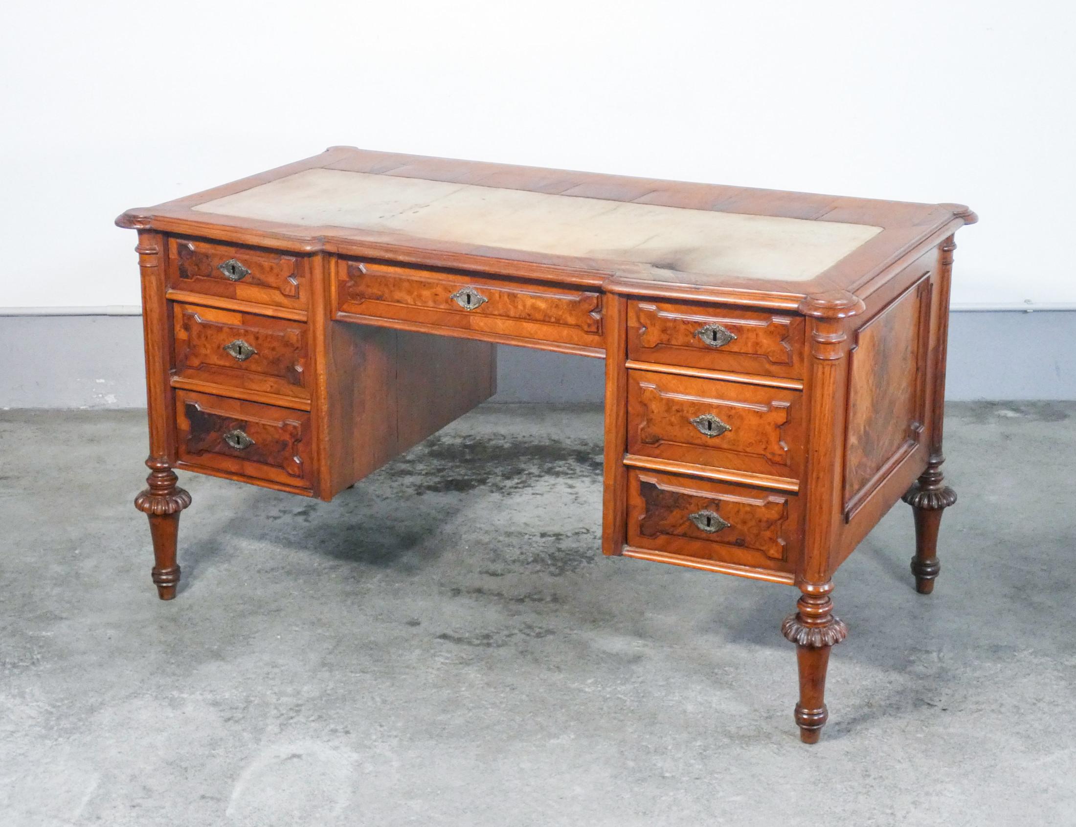 Victorian center desk, in walnut veneer and briar walnut, with seven drawers

ORIGIN
England

PERIOD
Early nineteenth century

MODEL
Center desk with seven drawers

MATERIALS
Veneered wood in walnut and briar