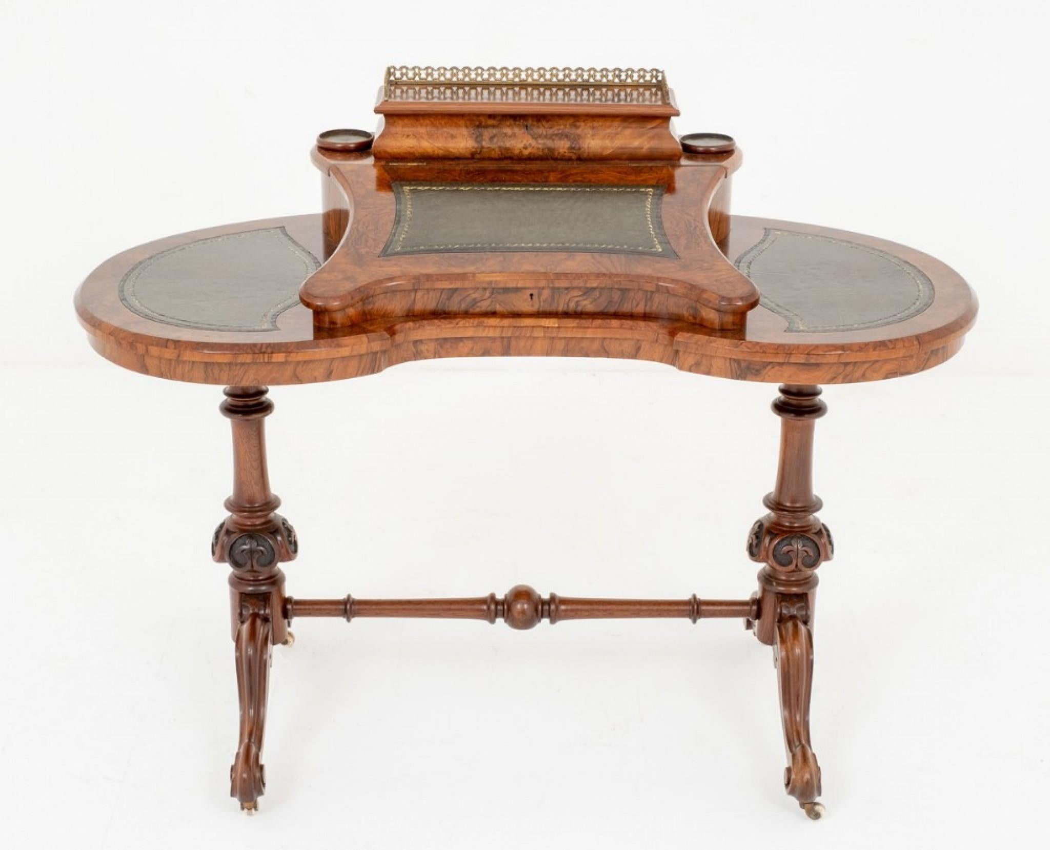 Pretty Victorian Walnut Shaped Writing Table.
Circa 1860
Standing on Shaped Carved Legs with a Ring Turned Stretcher and Turned and Carved Uprights.
The Kidney Shaped top featuring a raised writing slope with lift up pen and letter rack , topped